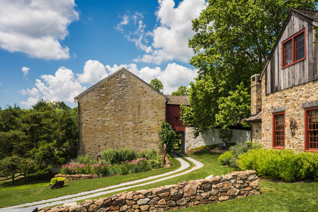 At this farmhouse, the use of stone walls and gravel roads divide up the property and areas of different types of gardens
