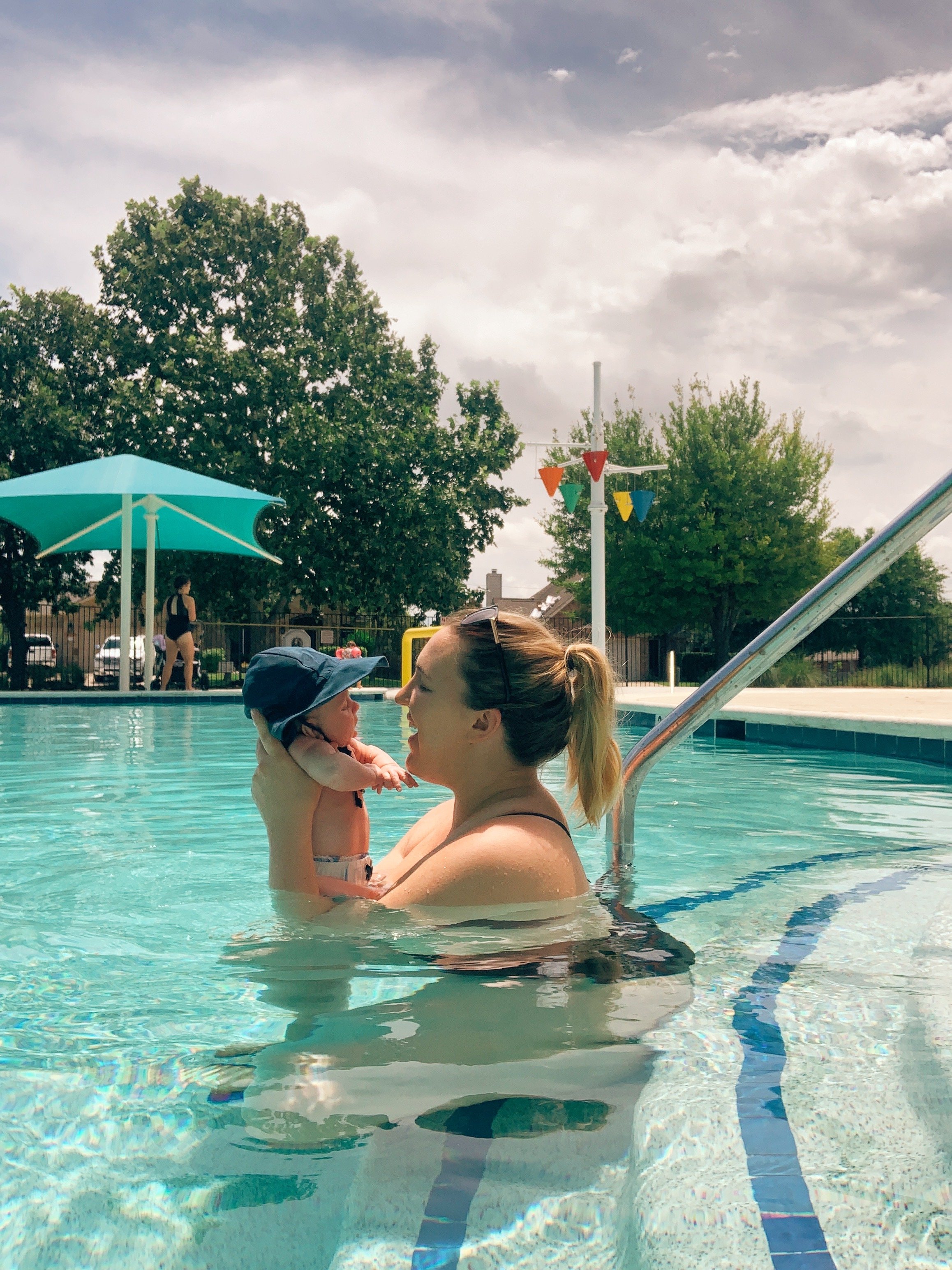 mom sits with baby in best pools in round rock for kids
