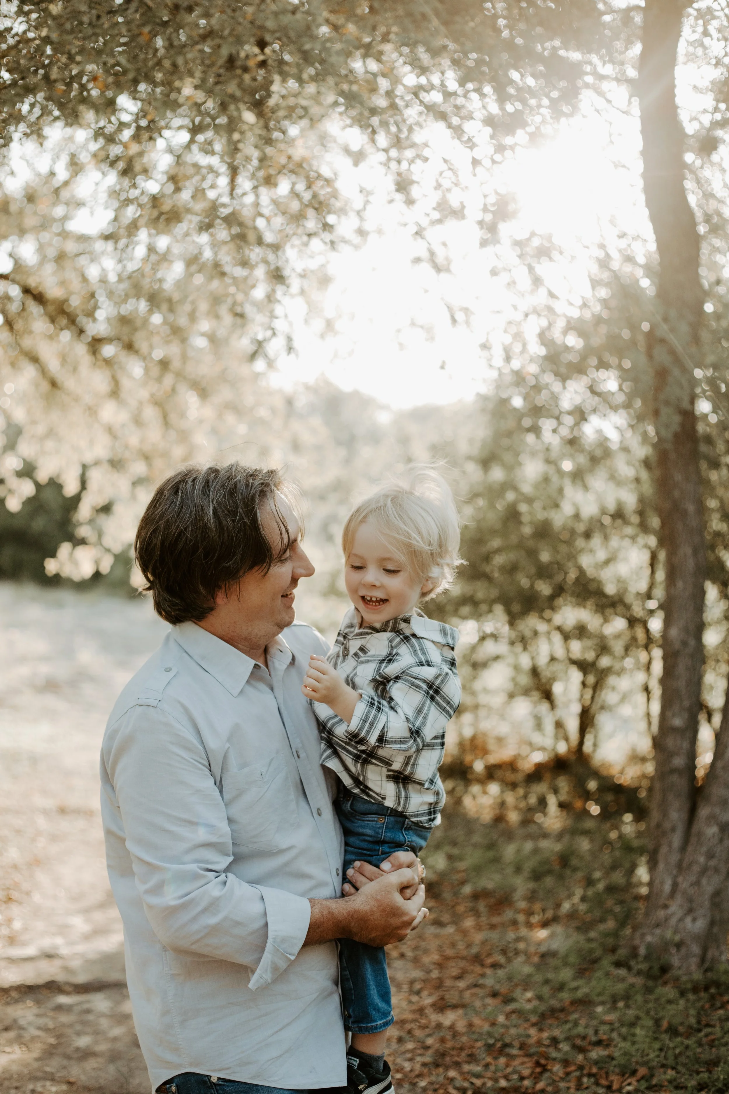 man snuggling his toddler in golden hour by Austin family photographer