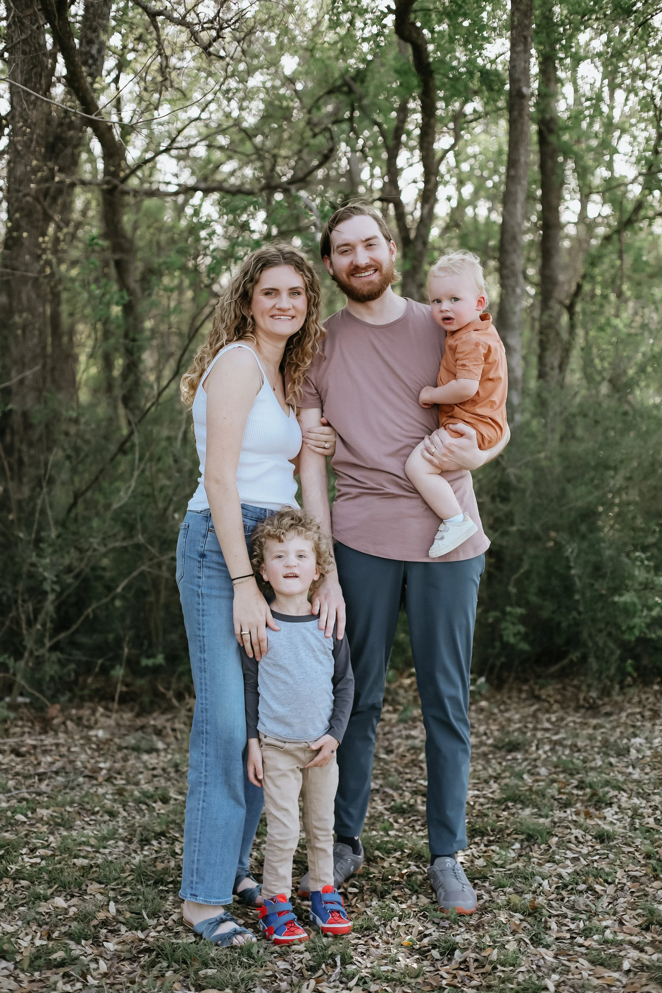 family with two toddler boys stands together for mini sessions