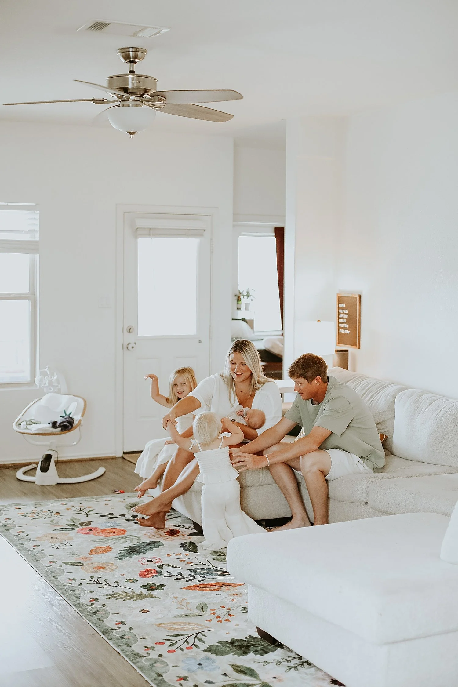 parents play with their kiddos on the couch for in-home newborn session