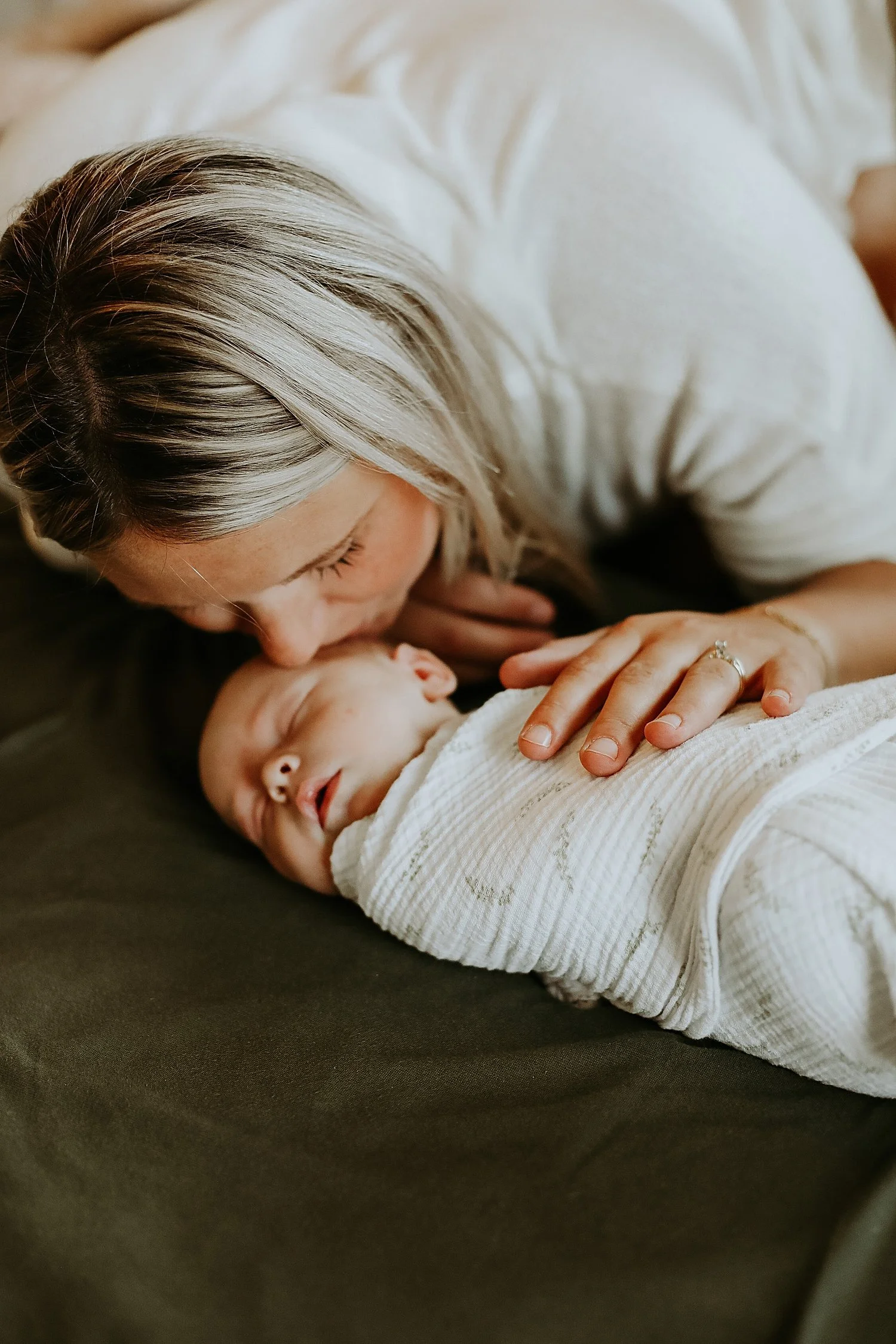 blonde mom leans down to kiss her new baby by Jessie Shaw photo