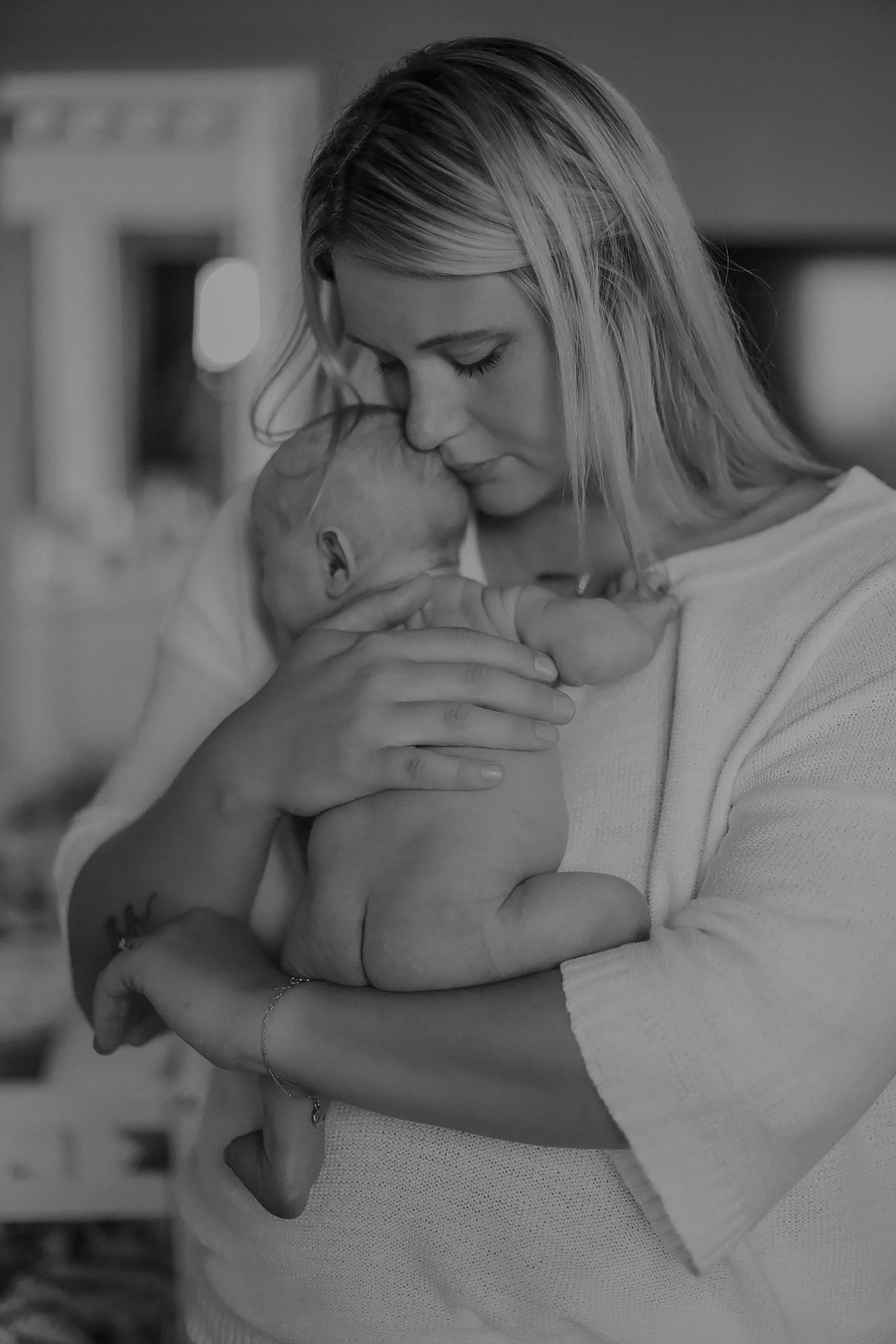 woman cradles a naked babe against her chest by Austin family photographer