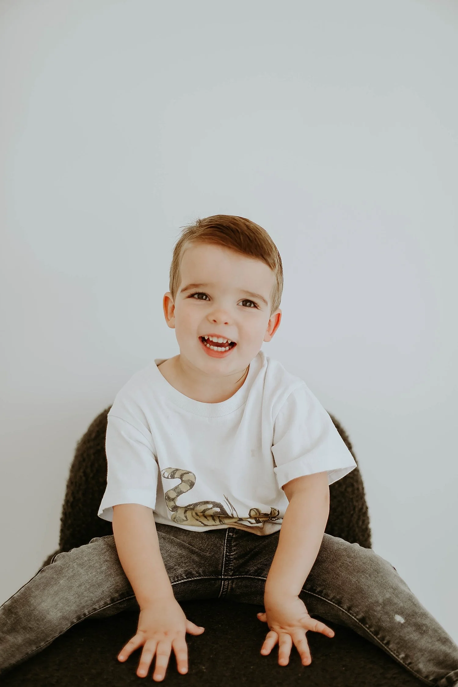  two year old sits on chair during Superhero Best Friend Shoot 