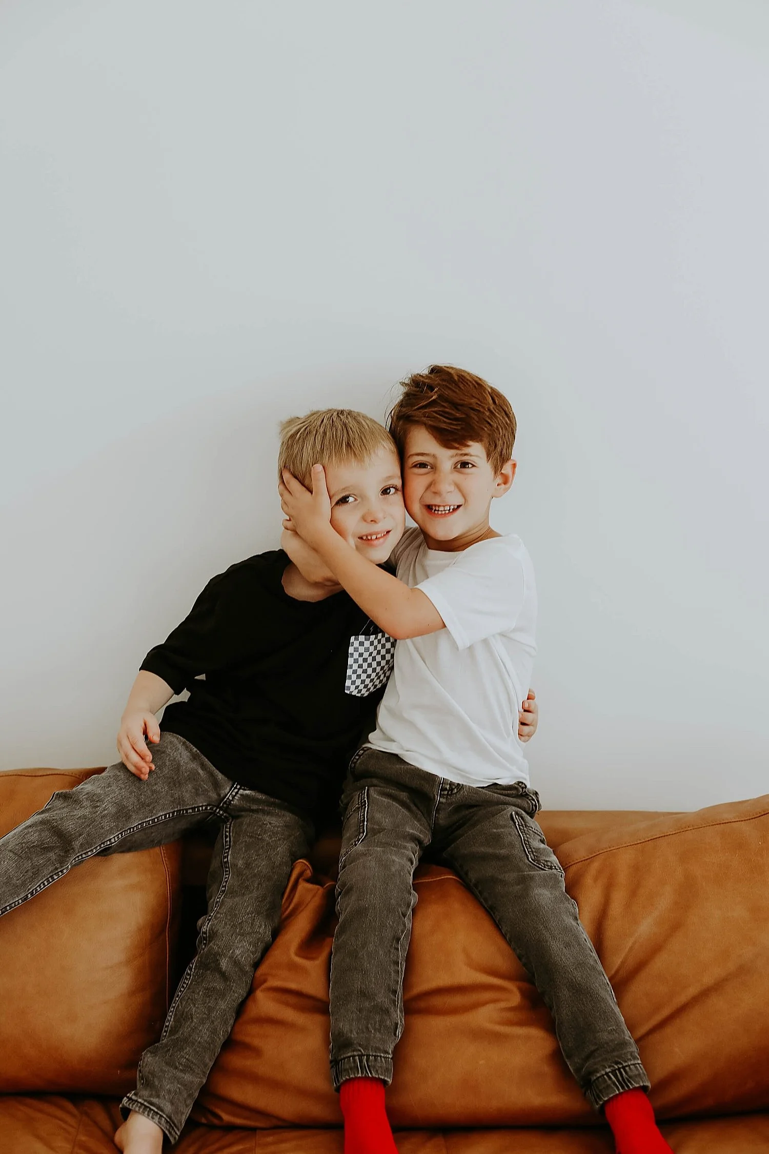  besties give each other a big hug on the back of a couch for Superhero Best Friend Shoot 