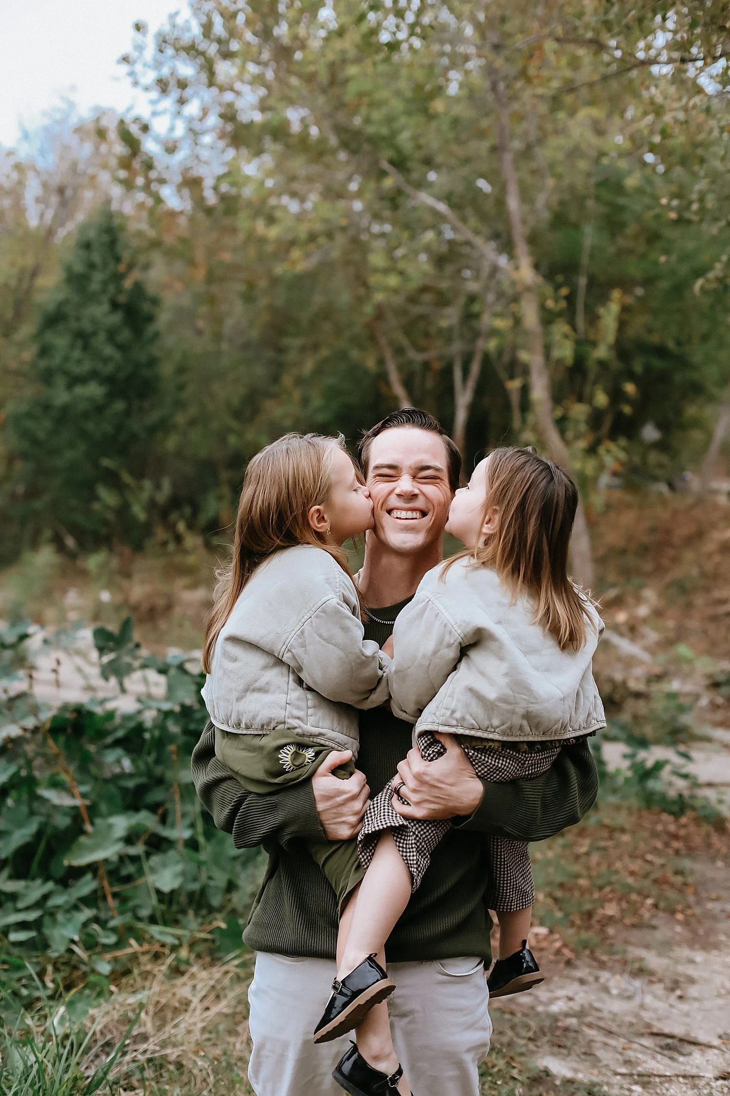  two toddler girls kiss their dad’s cheeks by Jessie Shaw Photo 