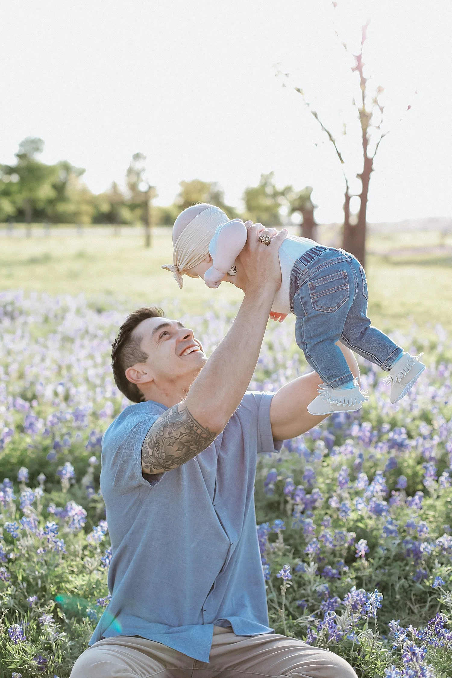  dad tosses baby in air in Texas bluebonnets by Austin family photographer 