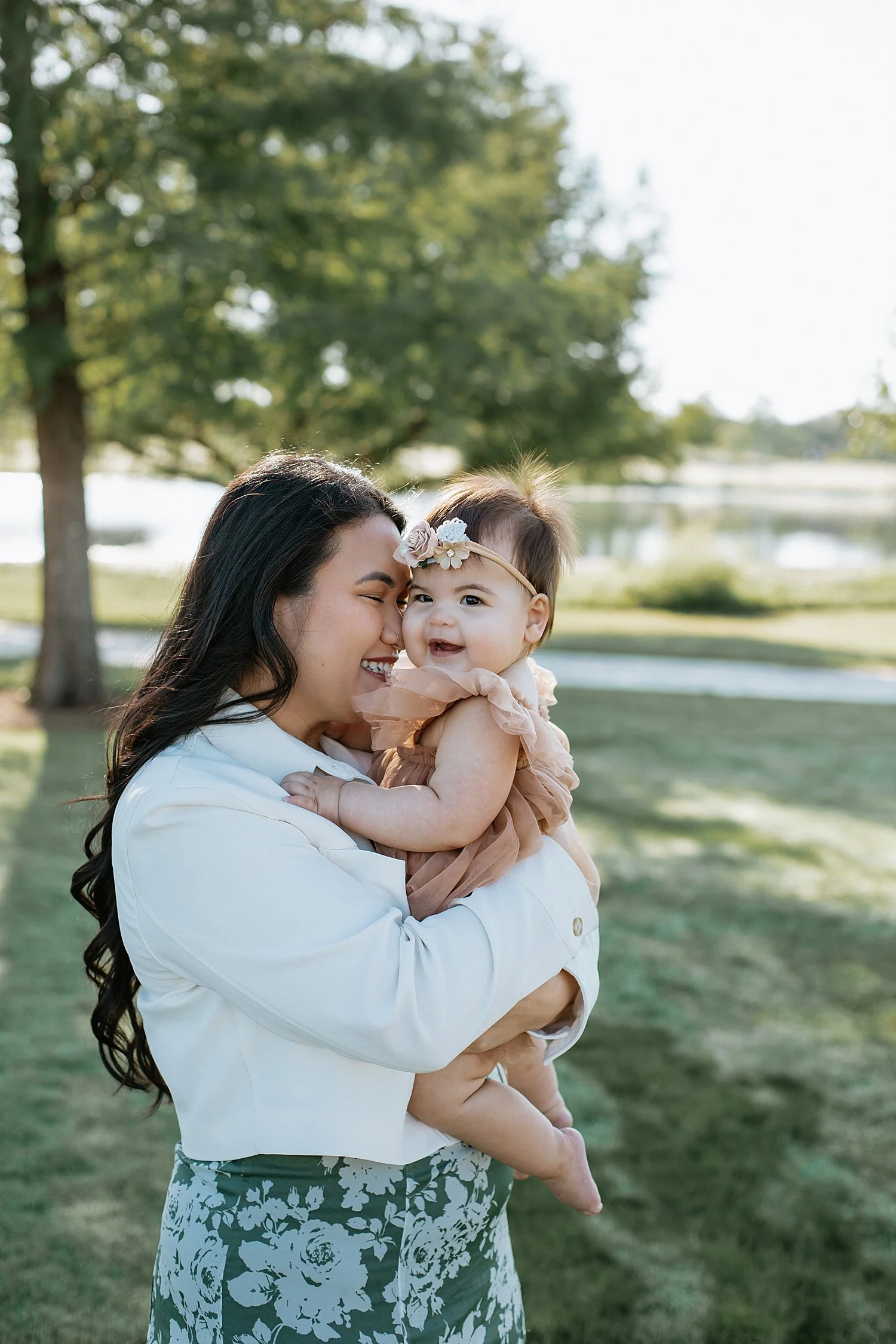  mom snuggles her toddler close near lake by Austin family photographer 