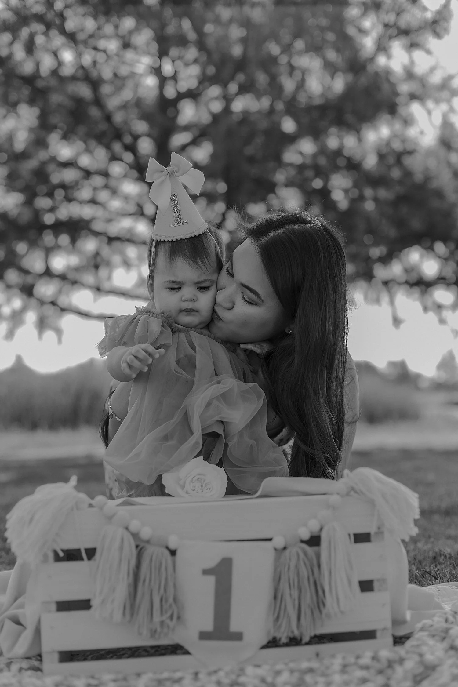  mother leans in to kiss her birthday baby on the cheek by Austin family photographer 