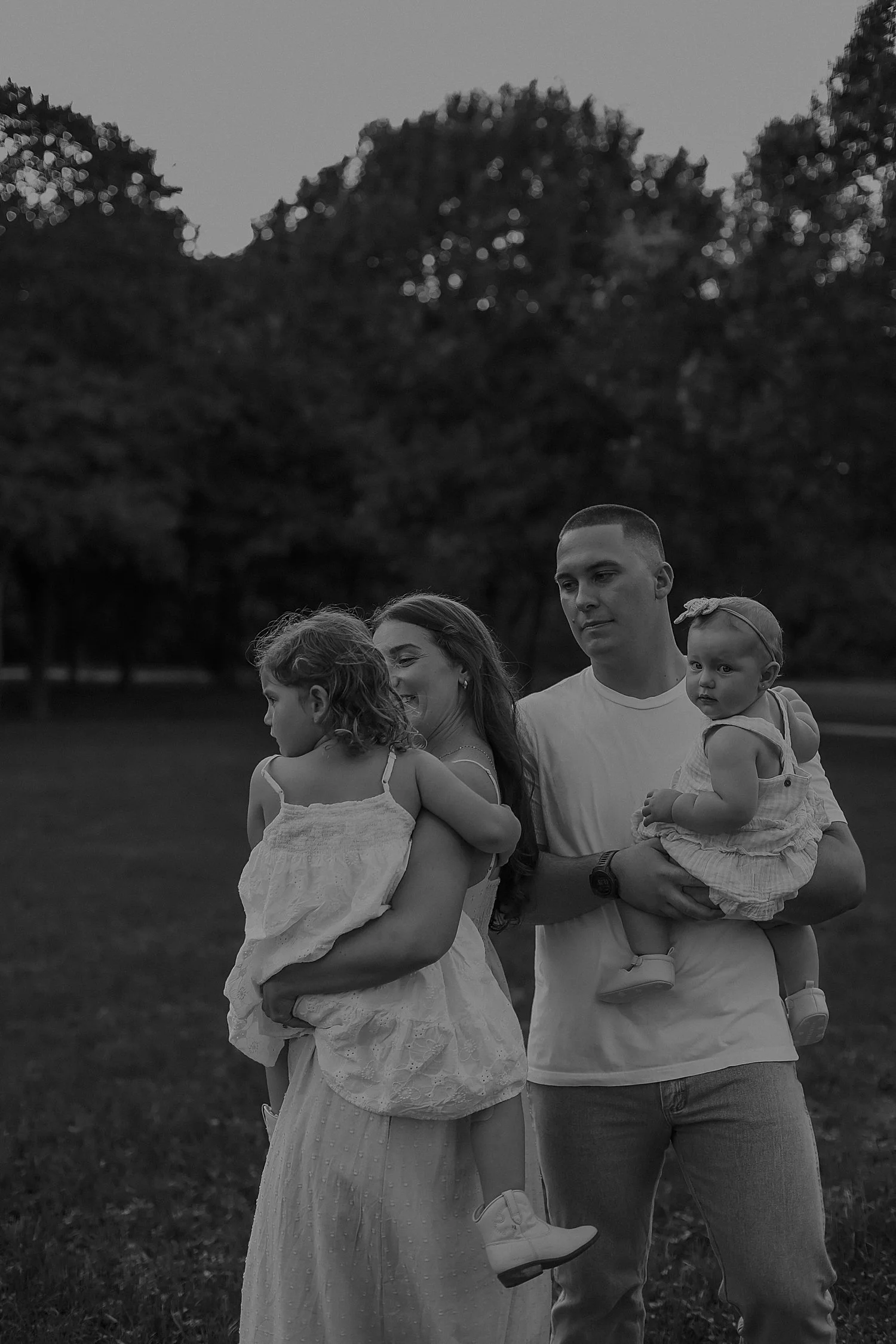  mom and dad look fondly at their toddlers for Spring family session 