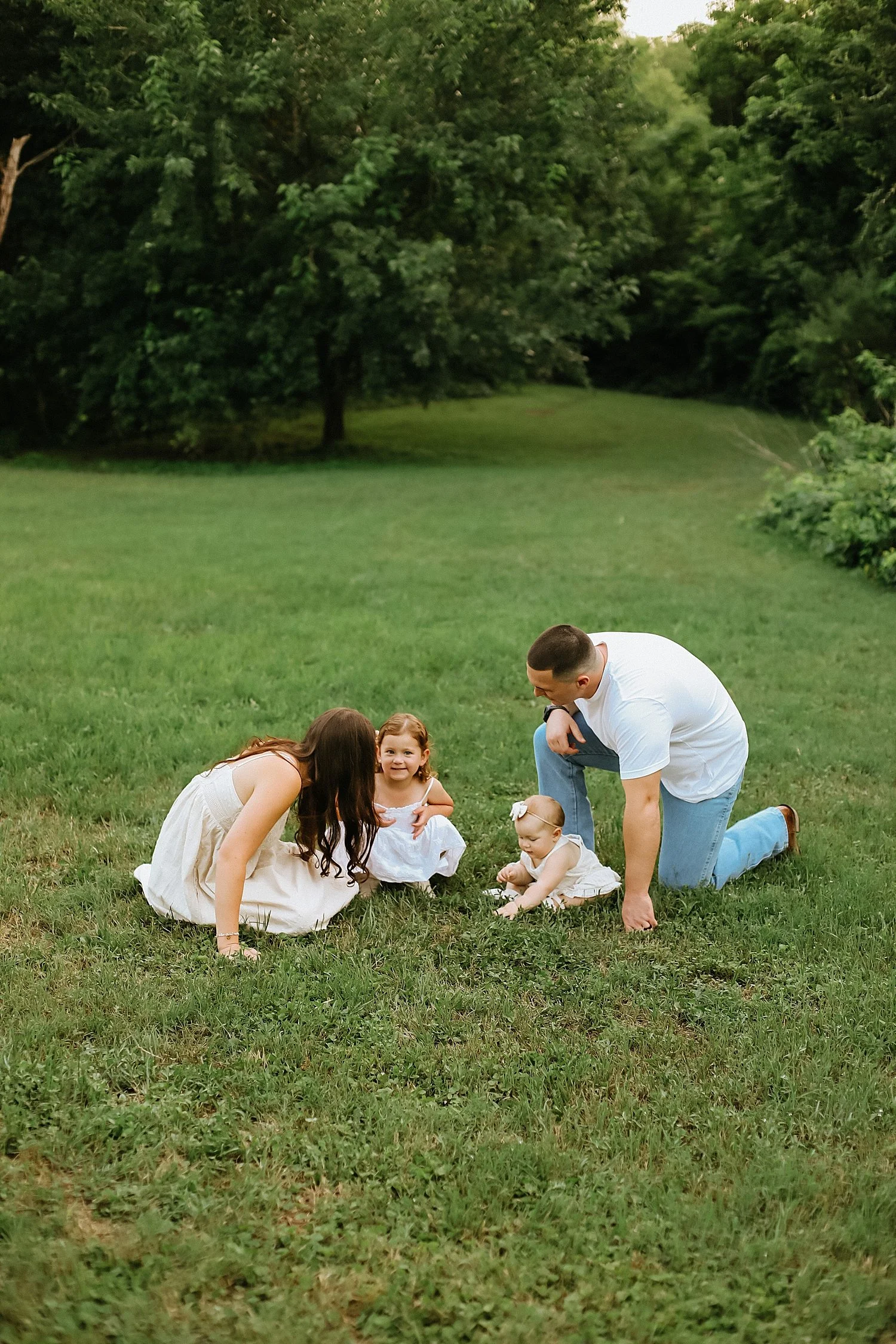  two people kneel on grass with their little babies by Jessie Shaw Photo 