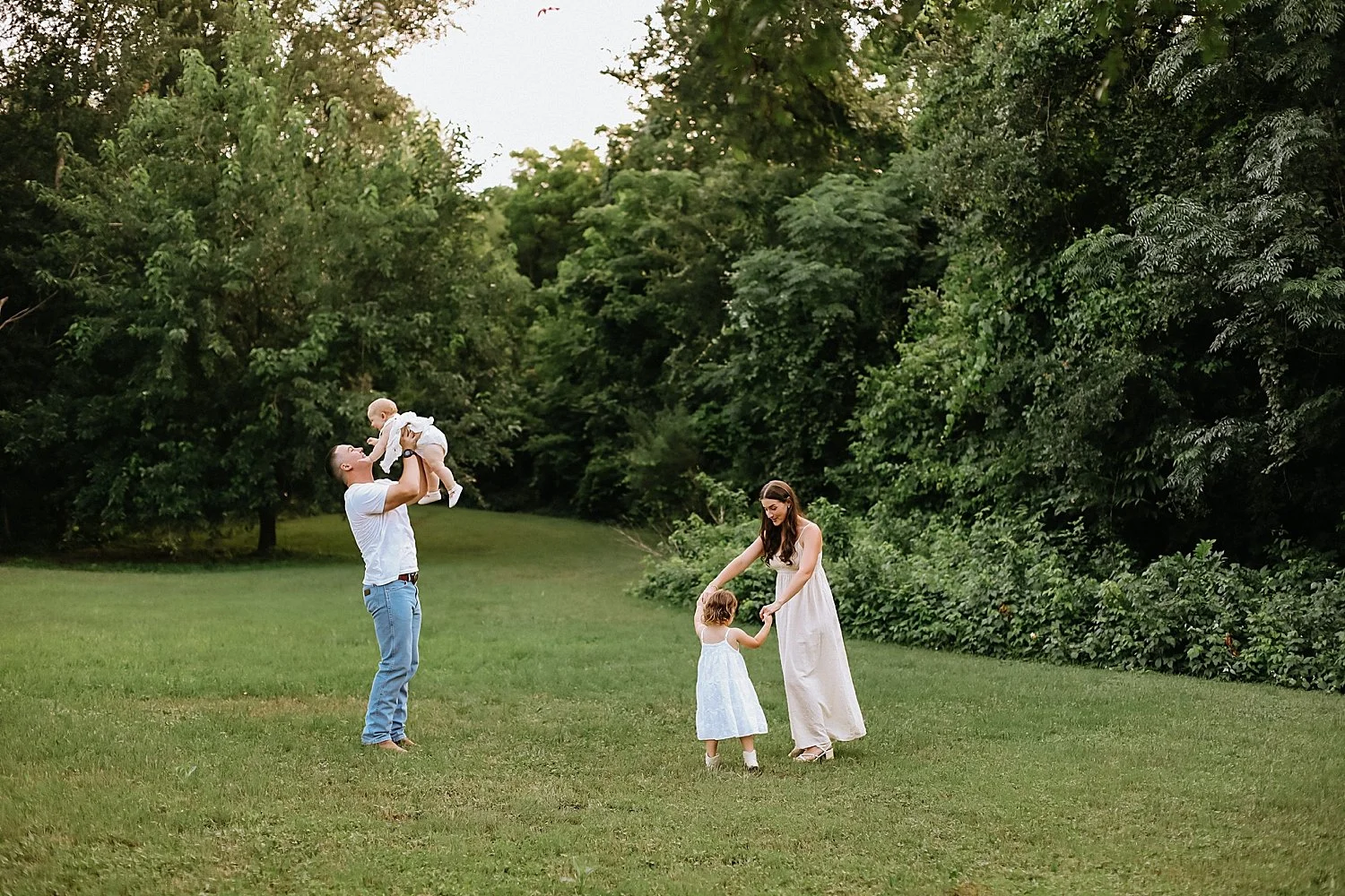  dad and mom play with their kids on lawn for Spring family session 