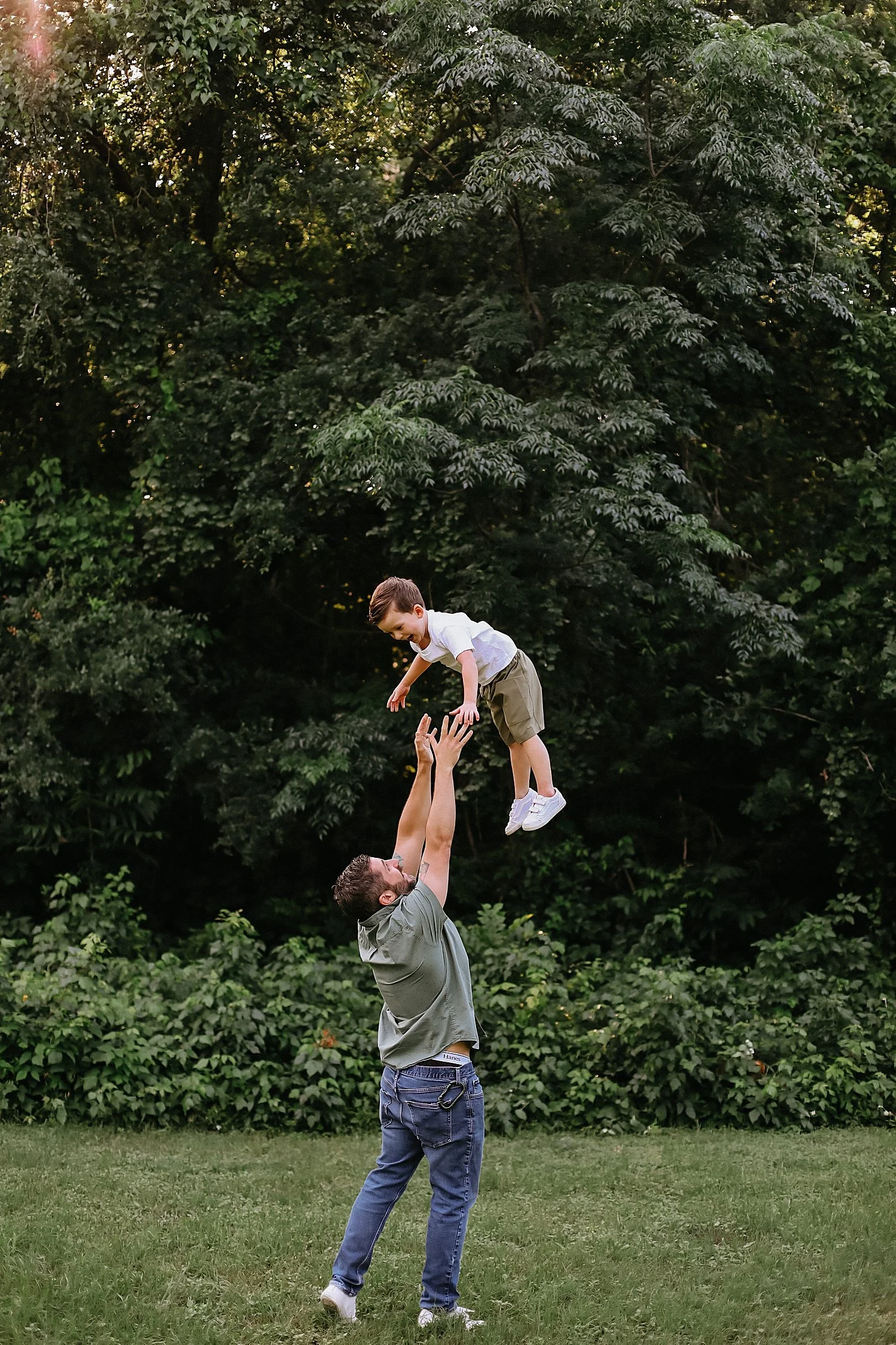  father tosses up kiddo in the air by Round Rock Family Photographer 