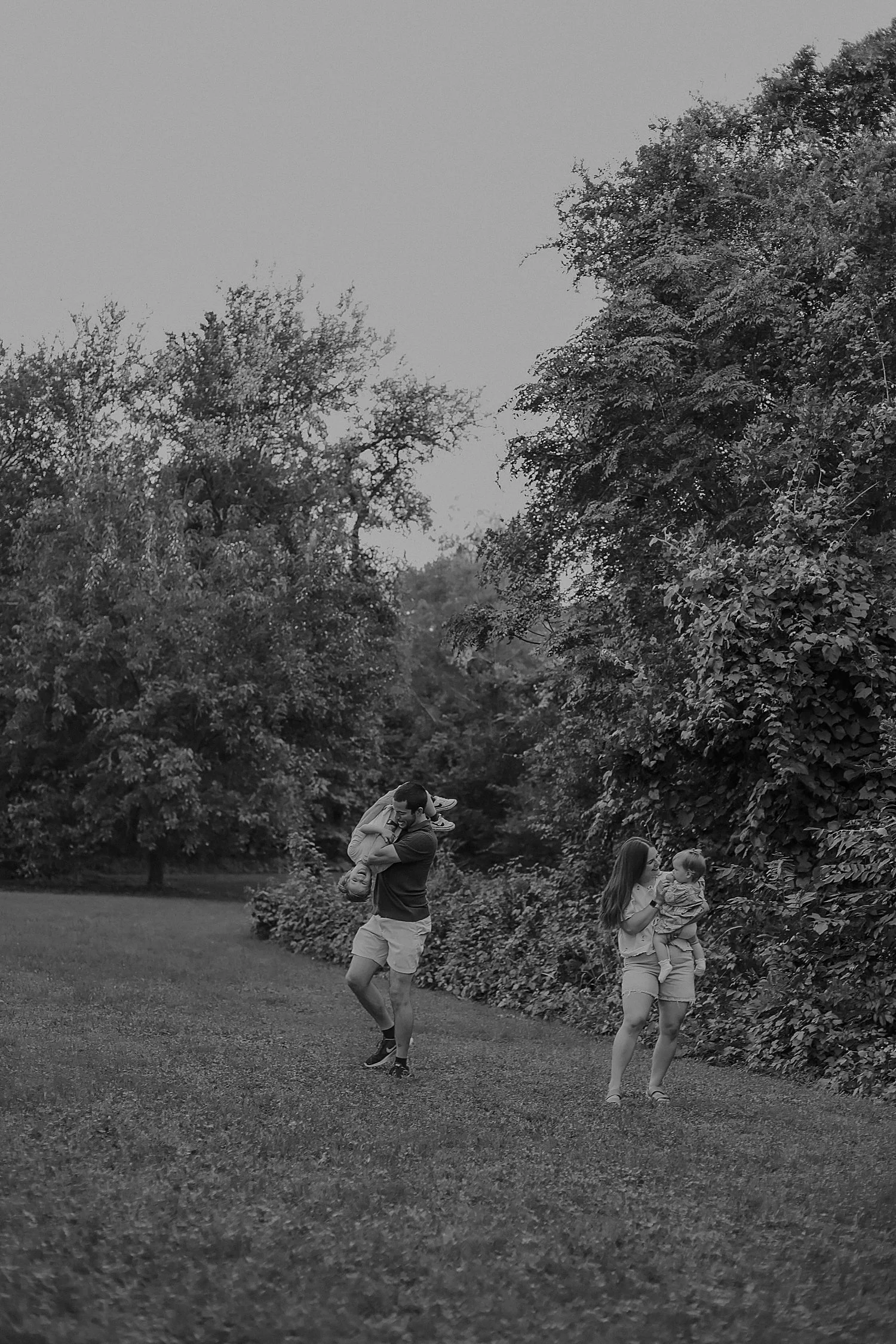  two parents play with their kids in park by Round Rock photographer 