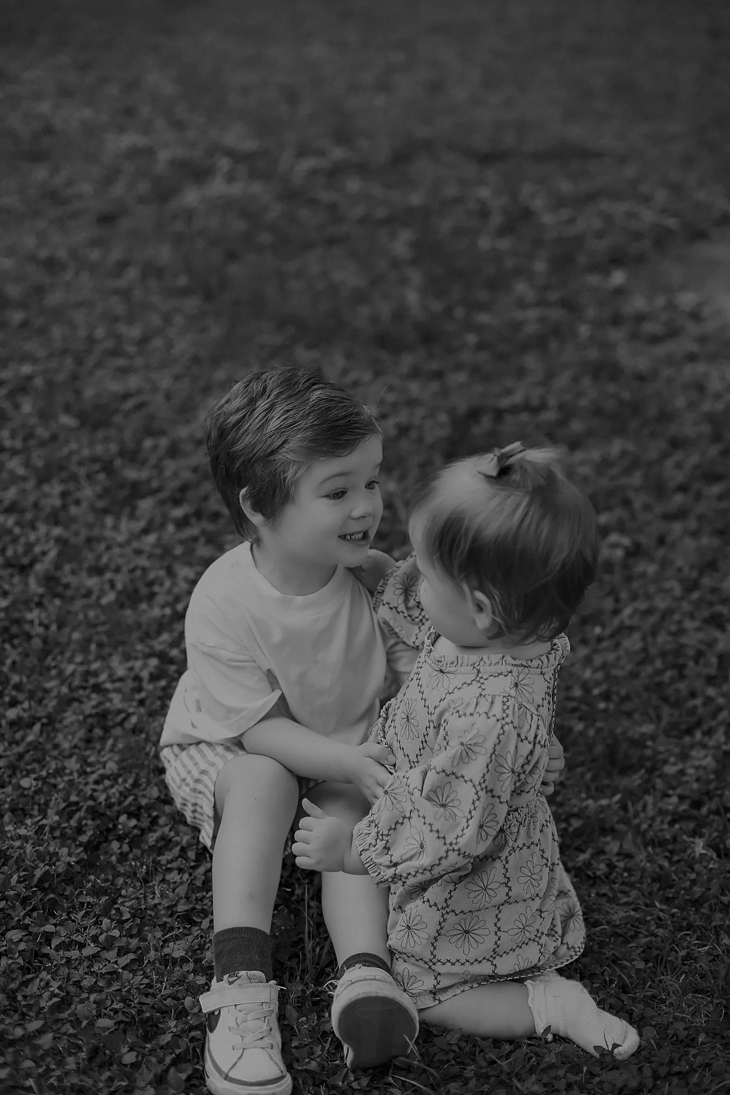  two toddlers play on grass together by Round Rock photographer 