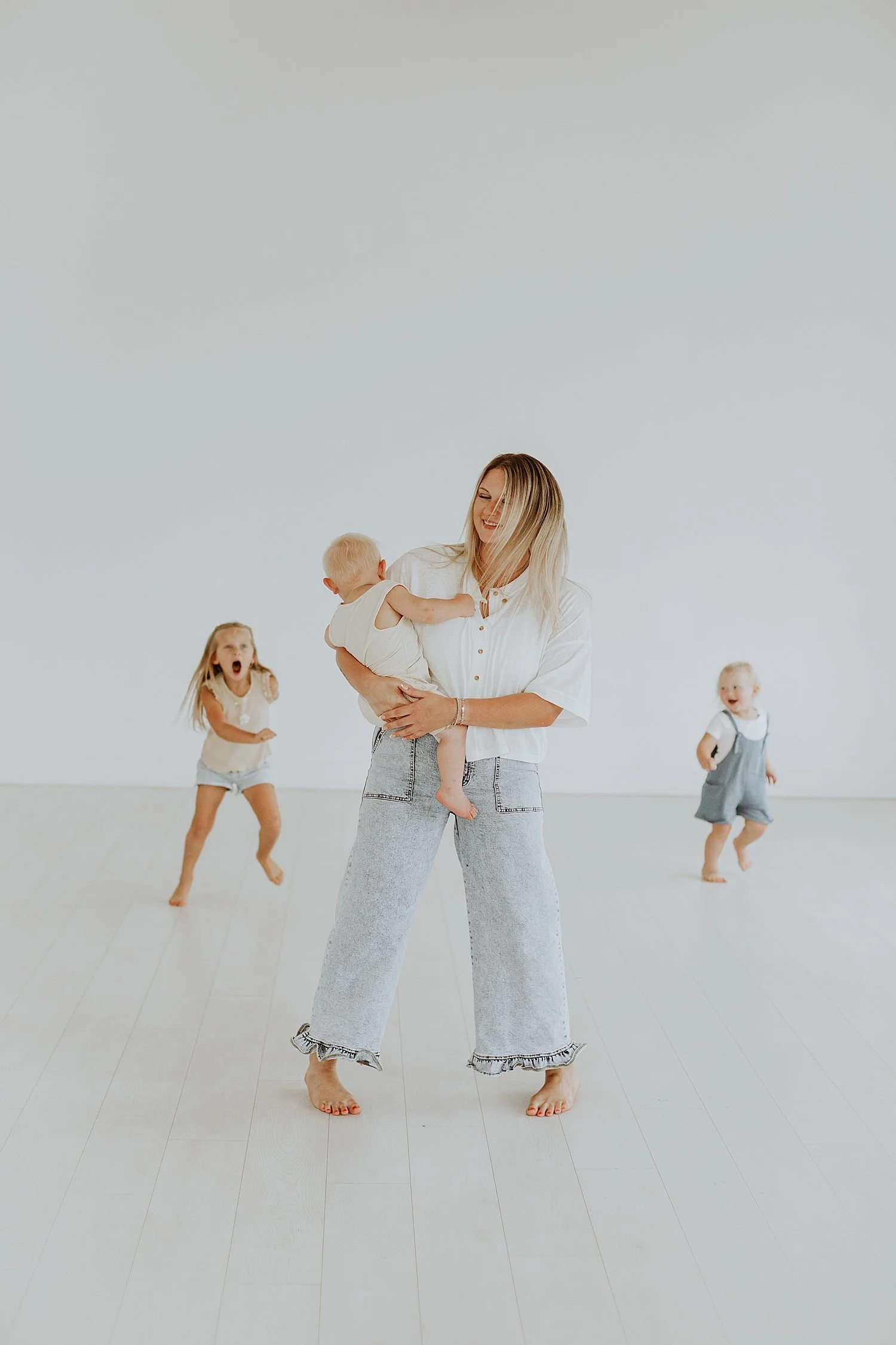  mother in jeans dances with small kids in studio by Round Rock family photographer 