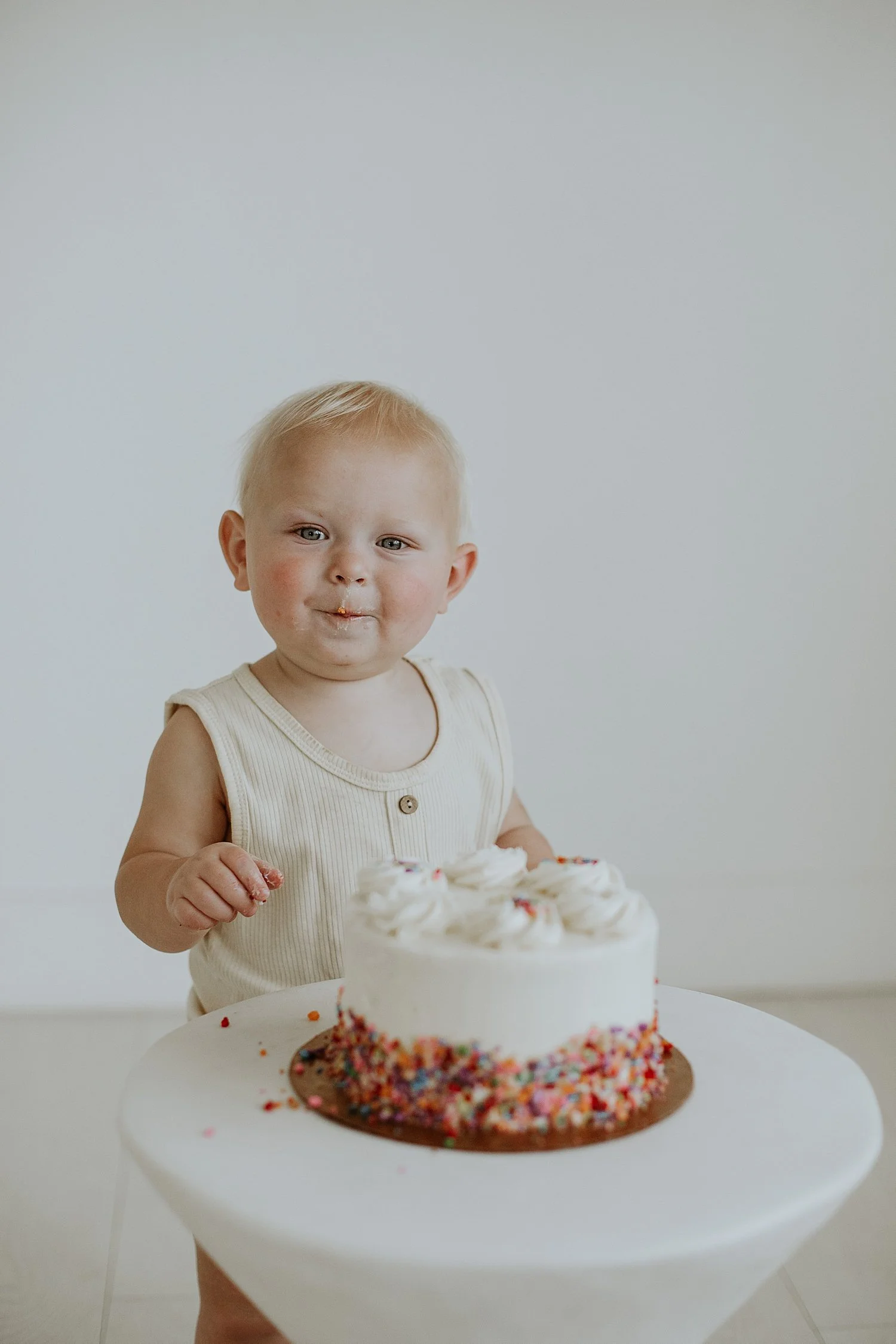  little boy stands in front of pebble cake on stand by Jessie Shaw Photo 