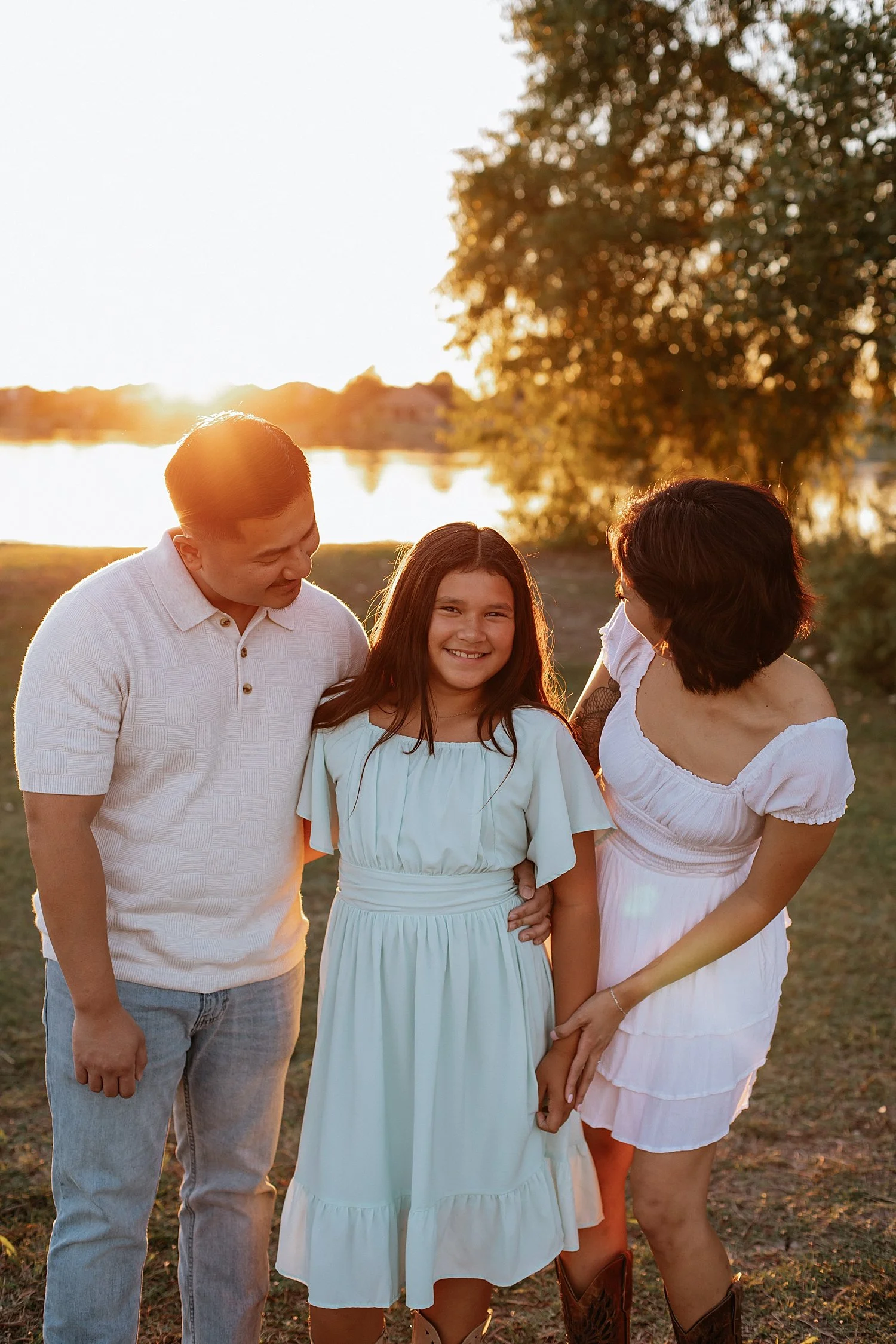 mom and dad smile with daughter for photo shoot at Lake Pflugerville 