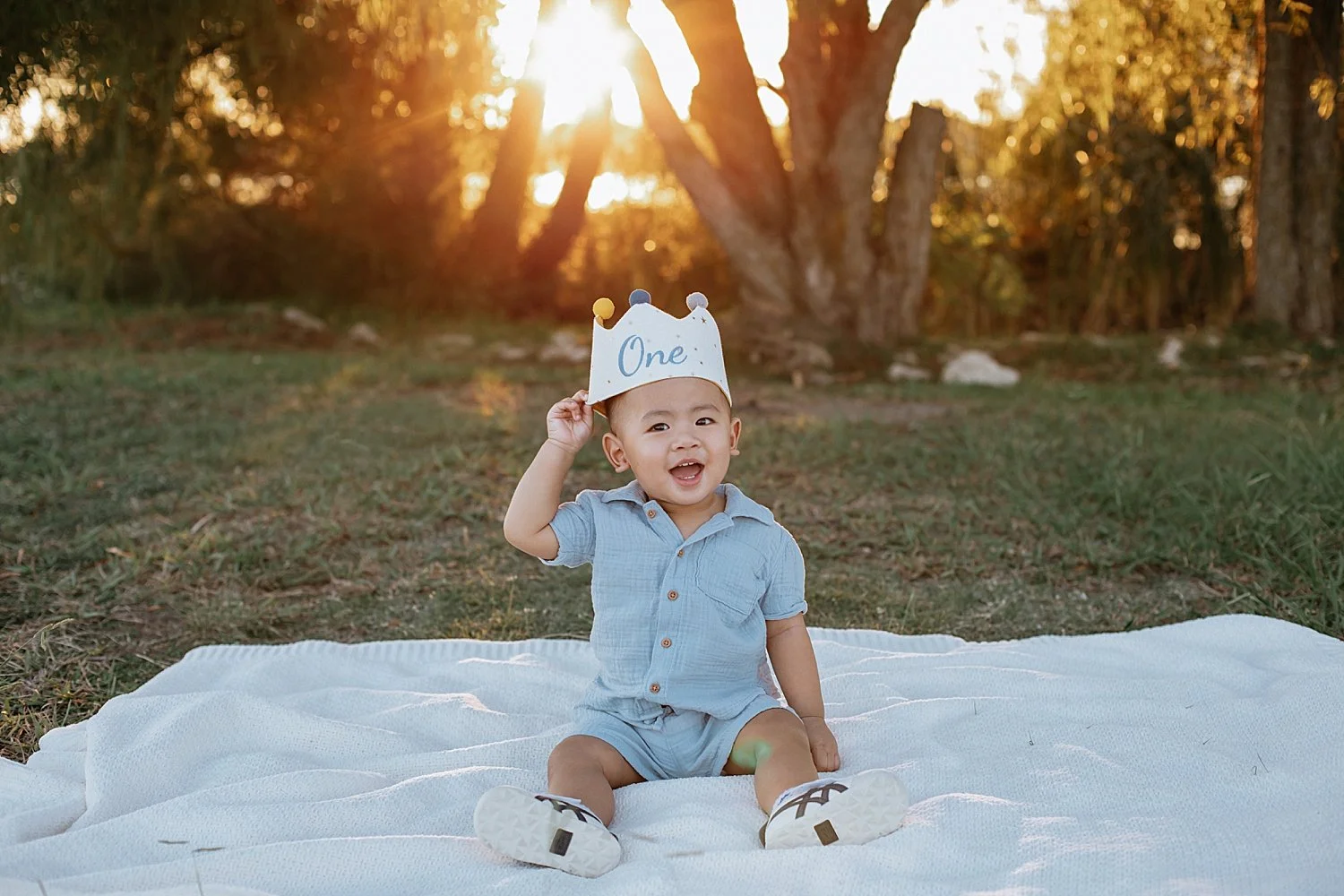  small boy sits on blanket with 1 crown on his head by Round Rock family photographer 