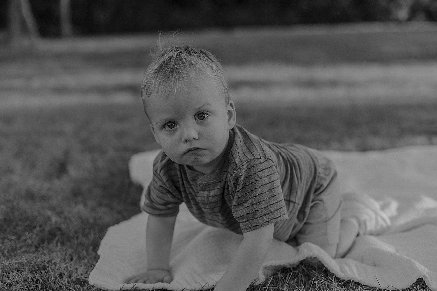  one year old crawls on white blanket outside by Jessie Shaw Photo 