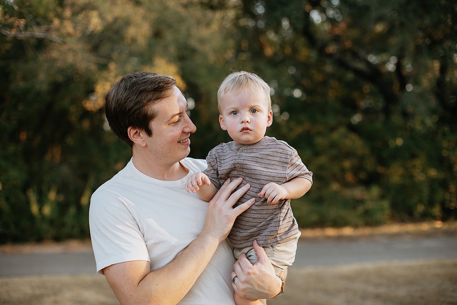  dad snuggles his little son at the park by Round Rock Family Photographer 