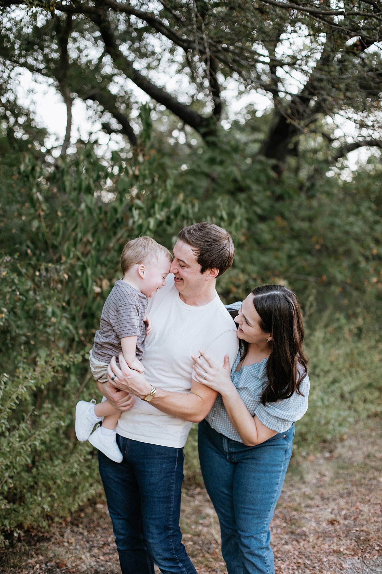  mom and dad play with one year old near trees by Jessie Shaw Photo 