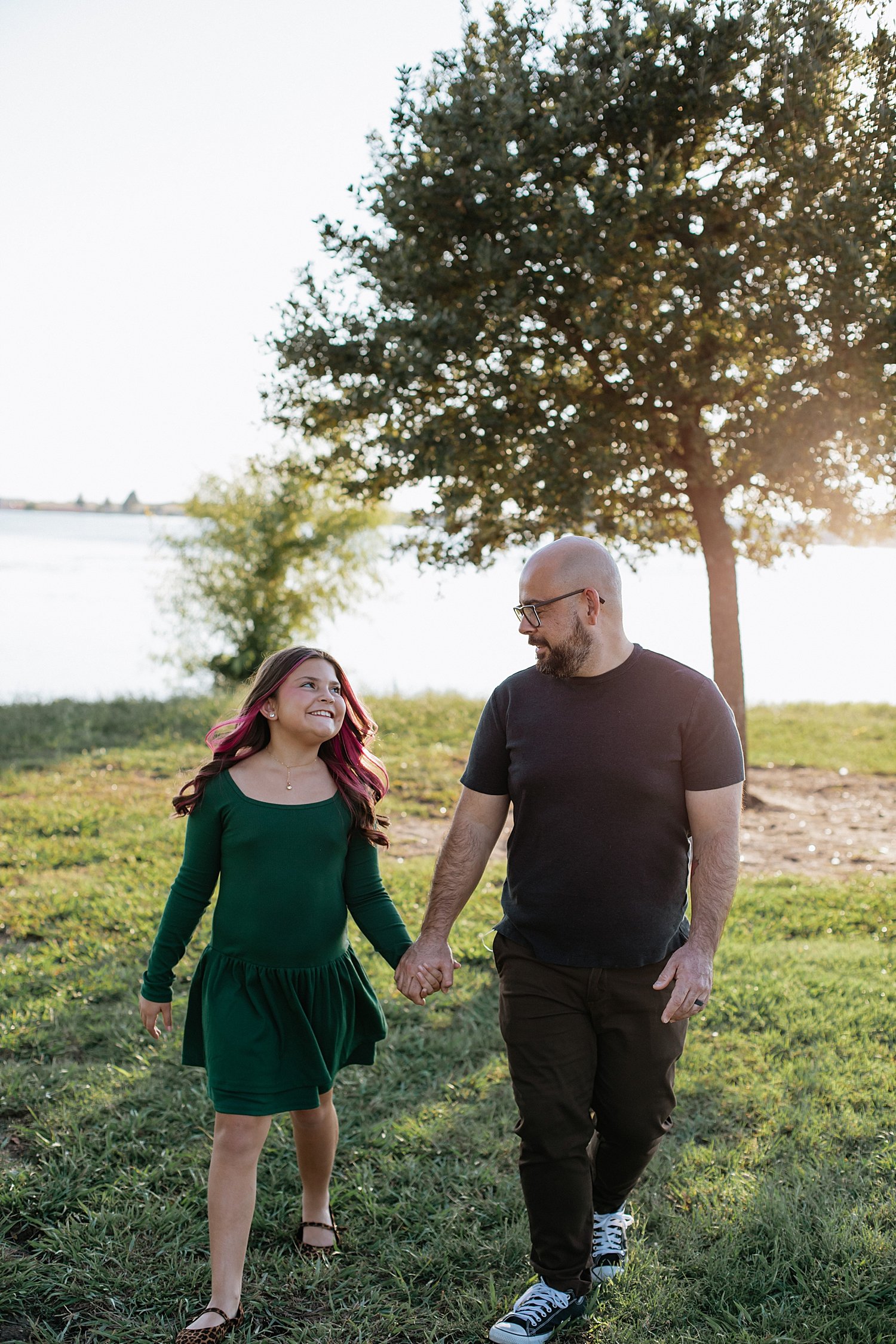  dad walks hand in hand with daughter by water by Round Rock family photographer 
