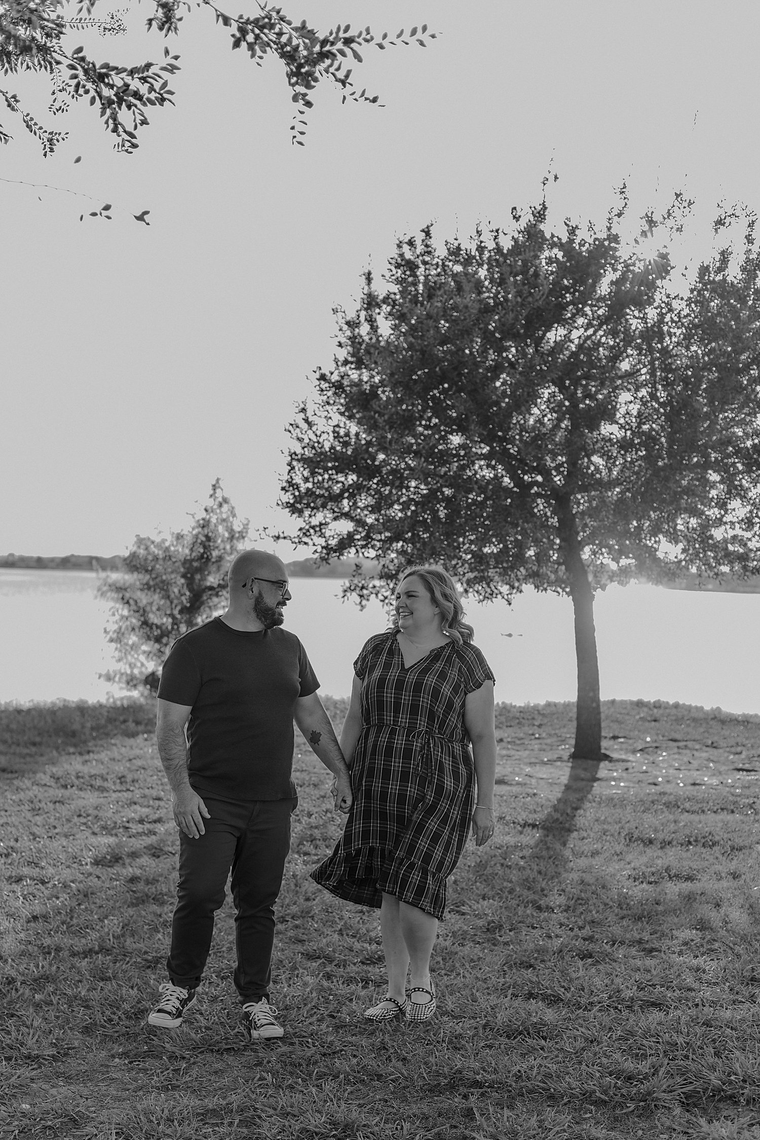  couple walk hand in hand across grass by Round Rock family photographer 