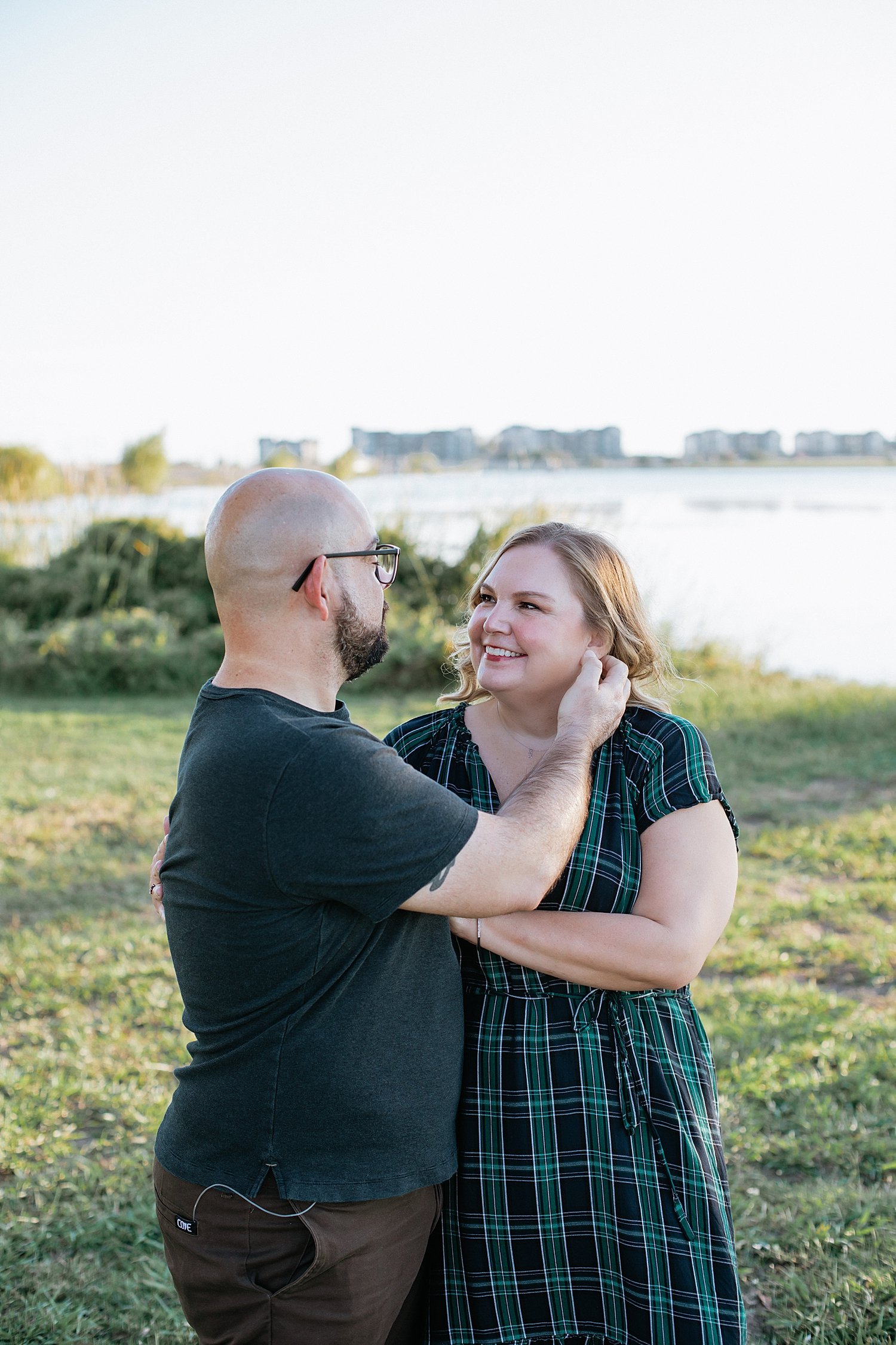  man reaches over to sweep woman’s hair behind ear by Jessie Shaw Photo 