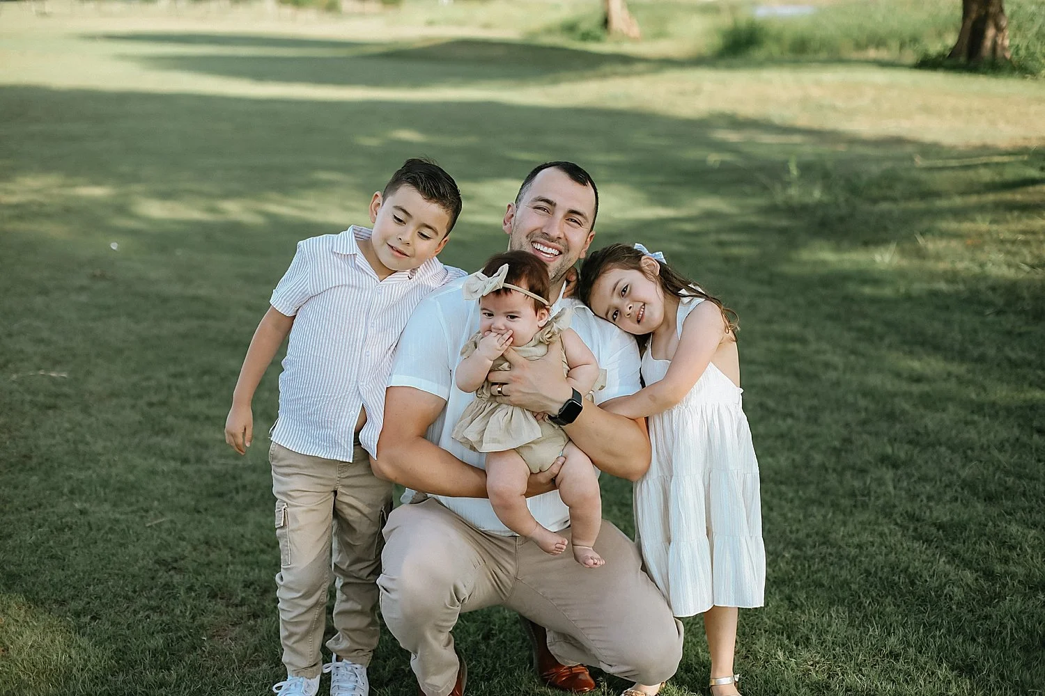  three kids snuggle dad for Spring session at Old Settlers Park 