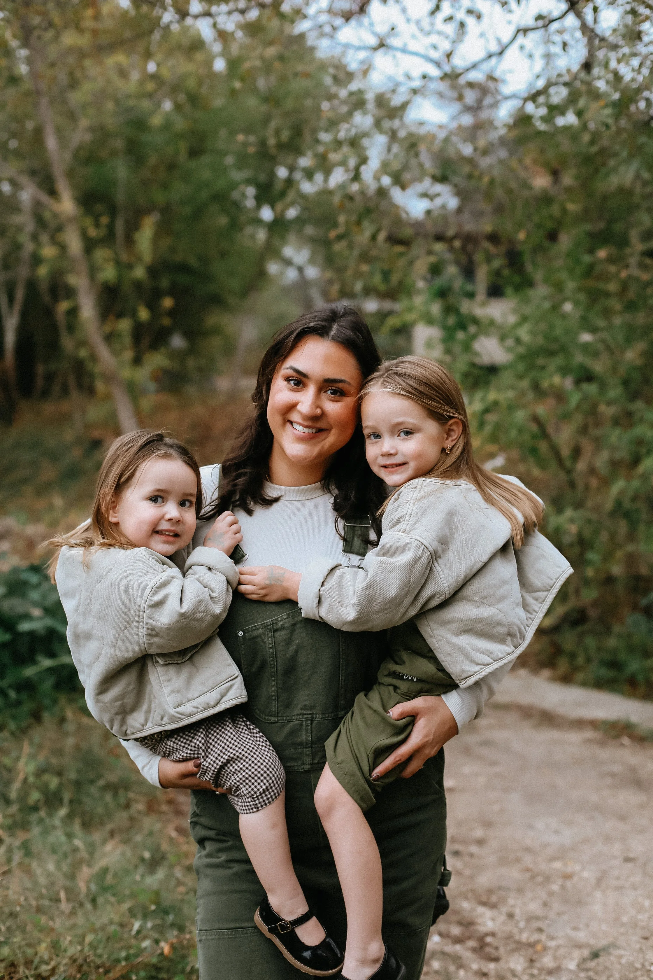 mother with two toddler girls on her hip by Austin family photographer