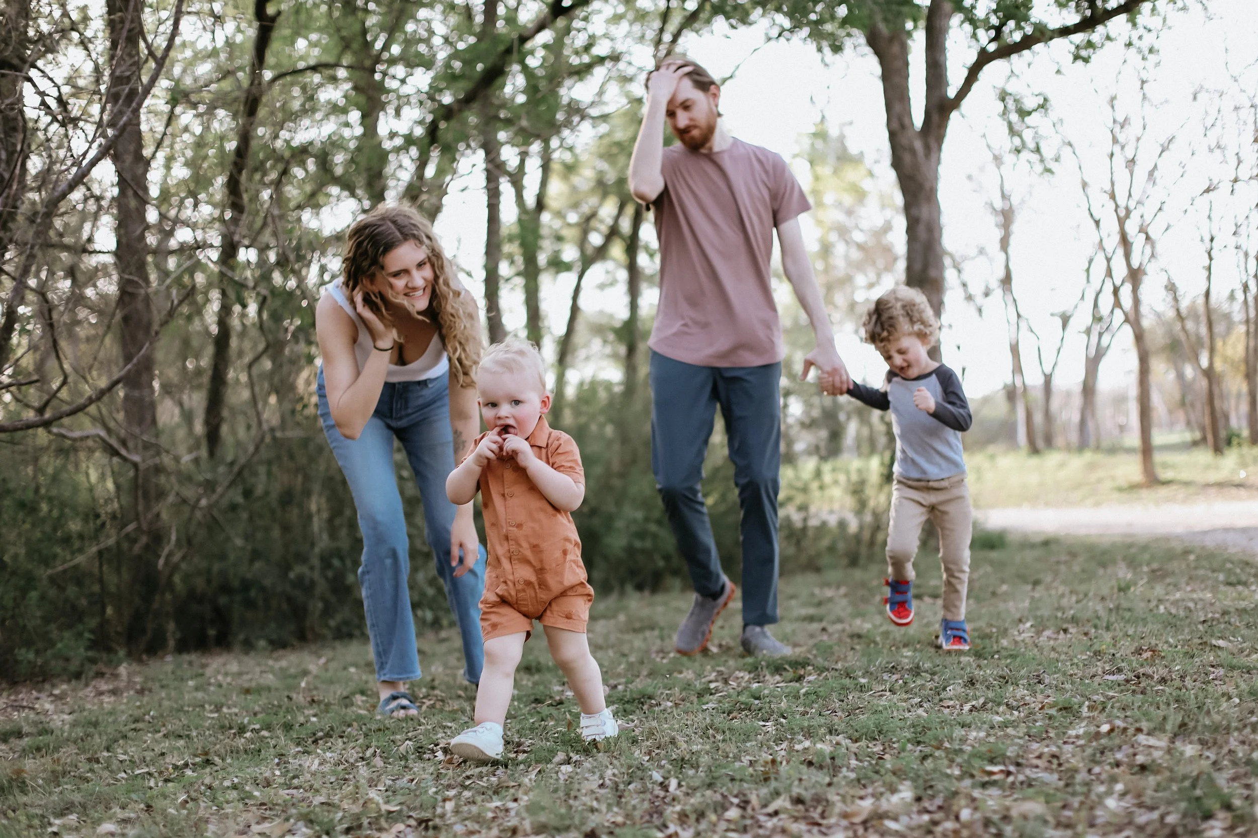 mom and dad follow their toddlers in park by Jessie Shaw Photo
