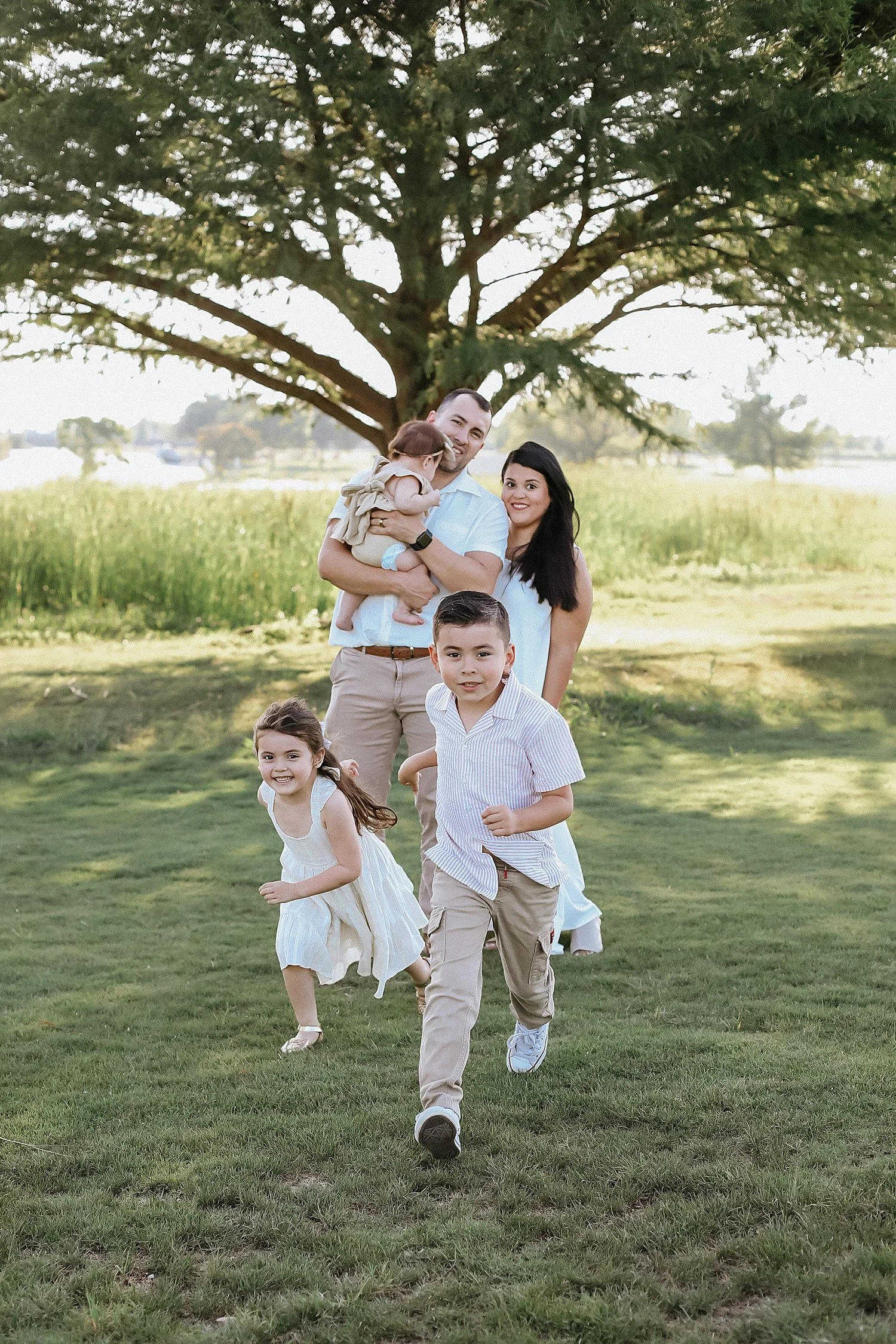 family of five plays under tree for documentary photography