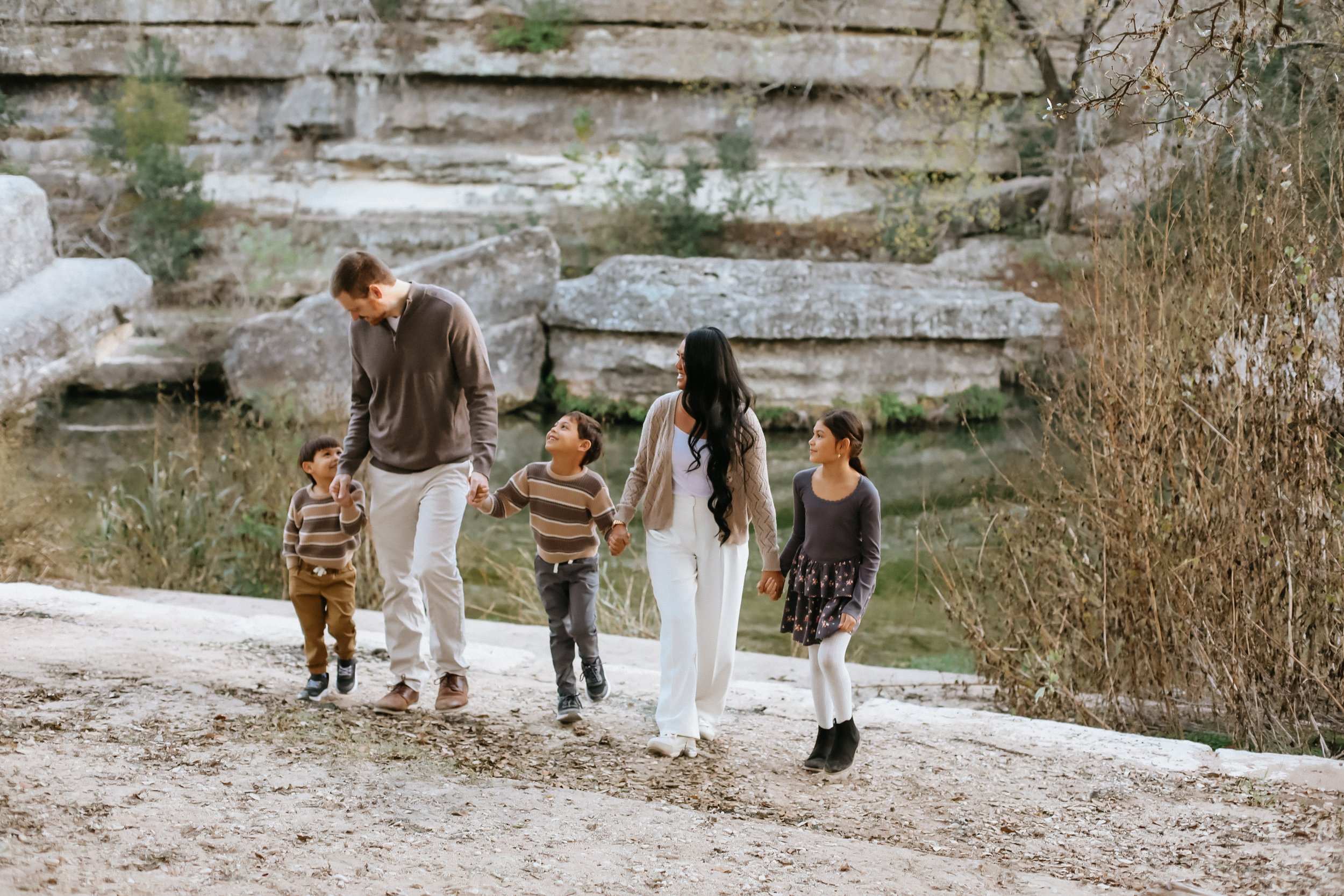 family of five walks up shoreline after discovering family-friendly places to eat in Round Rock