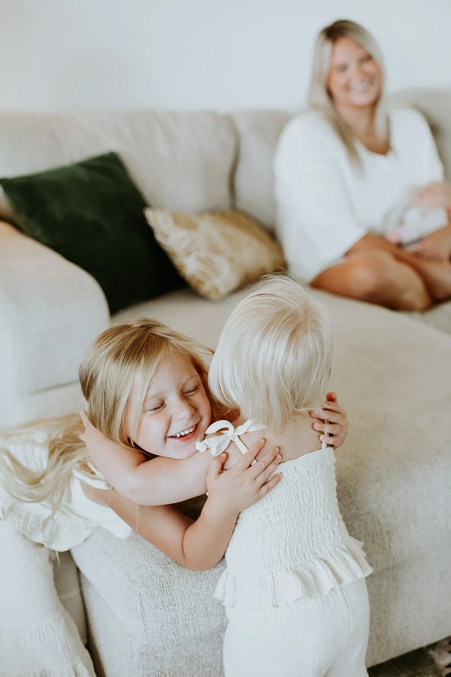 mom smiles as kids play together after learning what to wear for spring photos