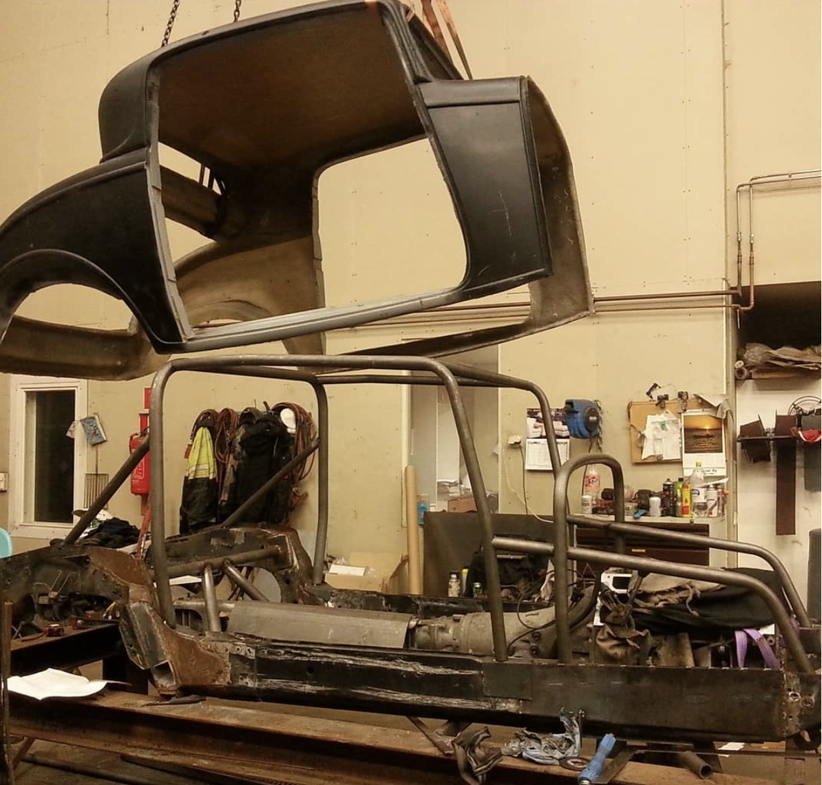 Fibreglass body being mounted to the frame.