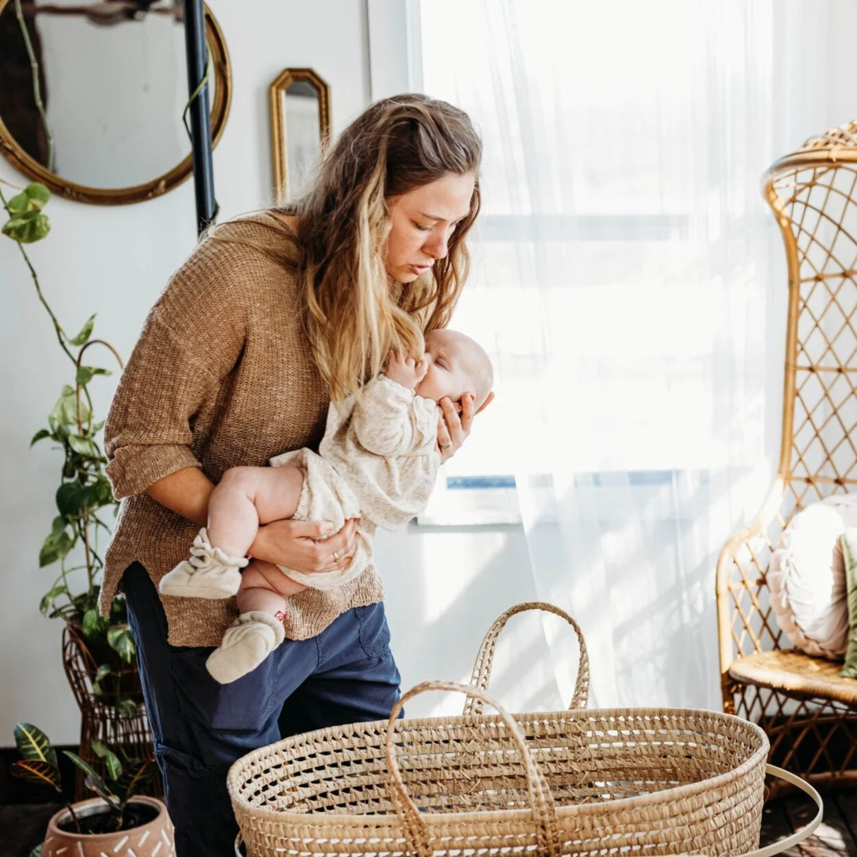 Sleep Coach putting sleeping baby into bassinet