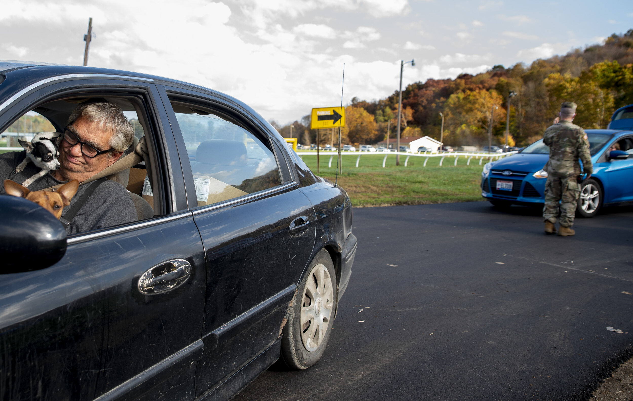  A man stops for a portrait before driving away from the Hocking County Fairgrounds after collecting food during the Southeast Ohio Food Bank’s food distribution day on Oct. 23, 2020 in Logan, Ohio.   