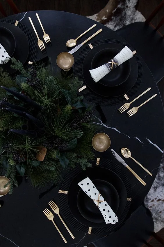 Mantel negro con cubiertos dorados