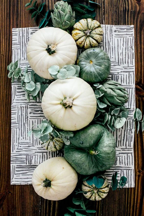 Combinar calabazas y plantas para un centro de mesa elegante