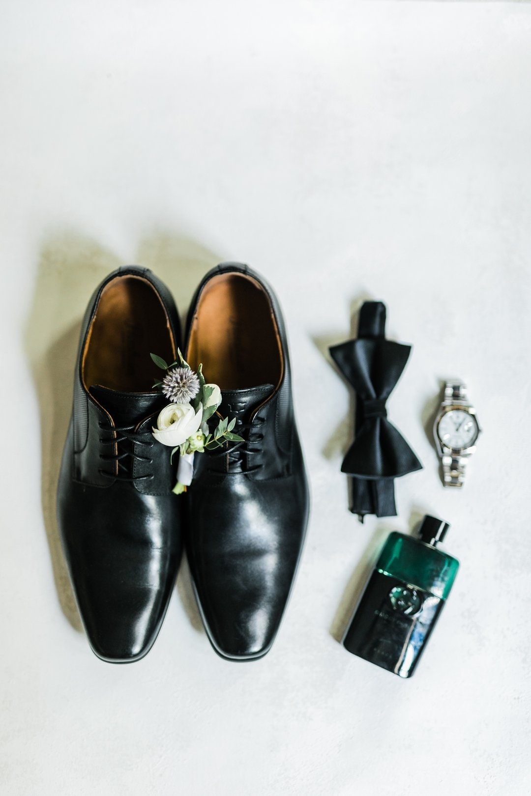 The perfect set up for a dapper groom: stylish shoes, a crisp bowtie, the perfect size boutonni&egrave;re, an elegant watch, and a hint of cologne. Someone is ready to make memories that last a lifetime.

Venue: @themansionatoysterbay
Planner: @jorda
