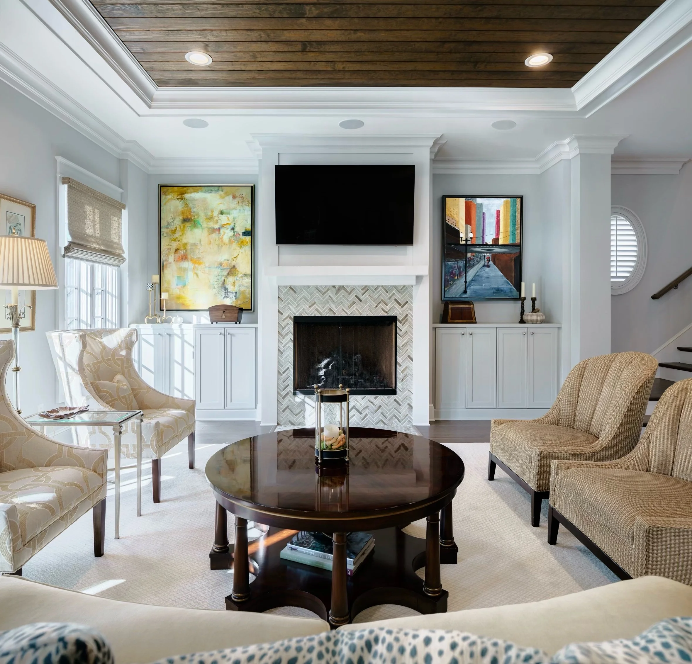 Luxurious living room, custom home elegance, contemporary fireplace with herringbone pattern, rich wooden ceiling, striking abstract artwork, soft neutral tones, comfortable beige seating, sleek black television, ambient recessed lights, crisp white
