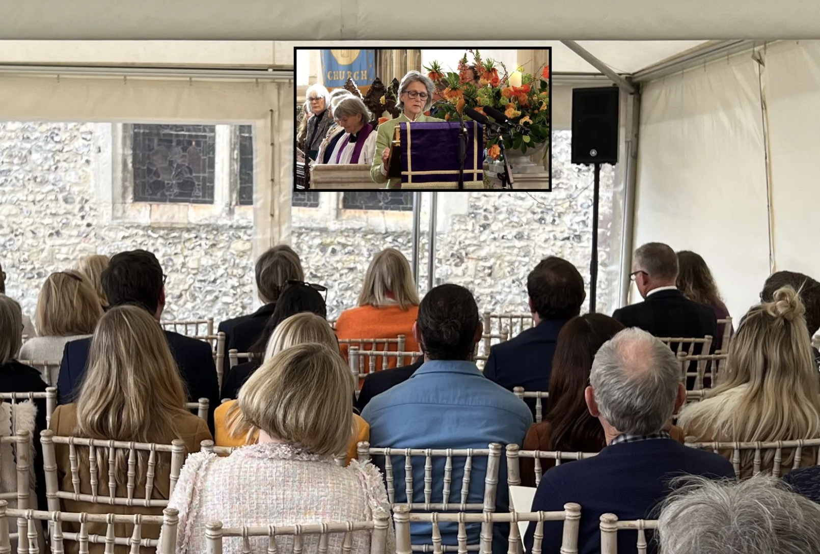 High-brightness outdoor TV screen displaying a live funeral service for overspill mourners outside a church