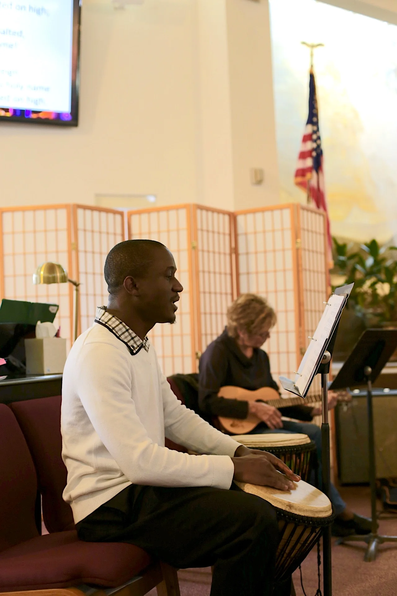 Garmondyu drummed lightly to accompany the gathering music. He said that church music in English sounds similar to what’s in Liberia, where there’s gospel music as well. Photo by Jiaman (Maggie) Peng .