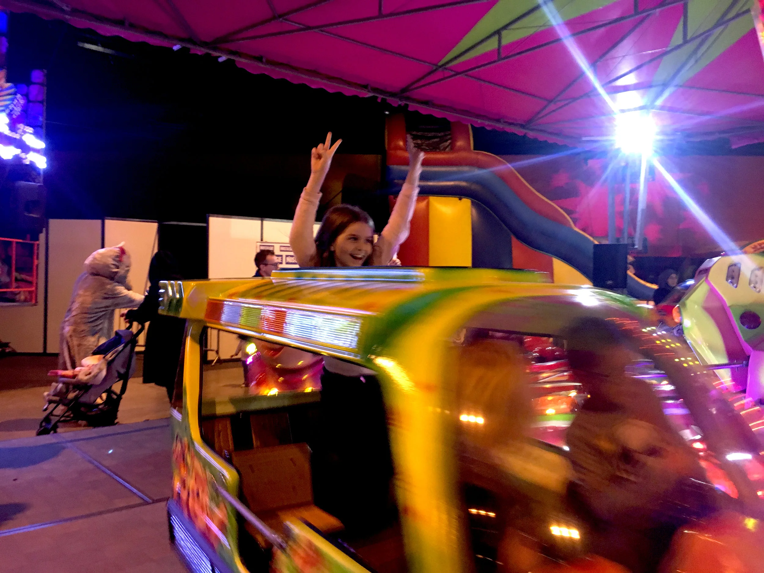 Elma rides one of the many carnival rides at the fun fair. The event had multiple games and rides for the families such as an air rifle game and bumper cars. Photo courtesy: Amy Nakamura .