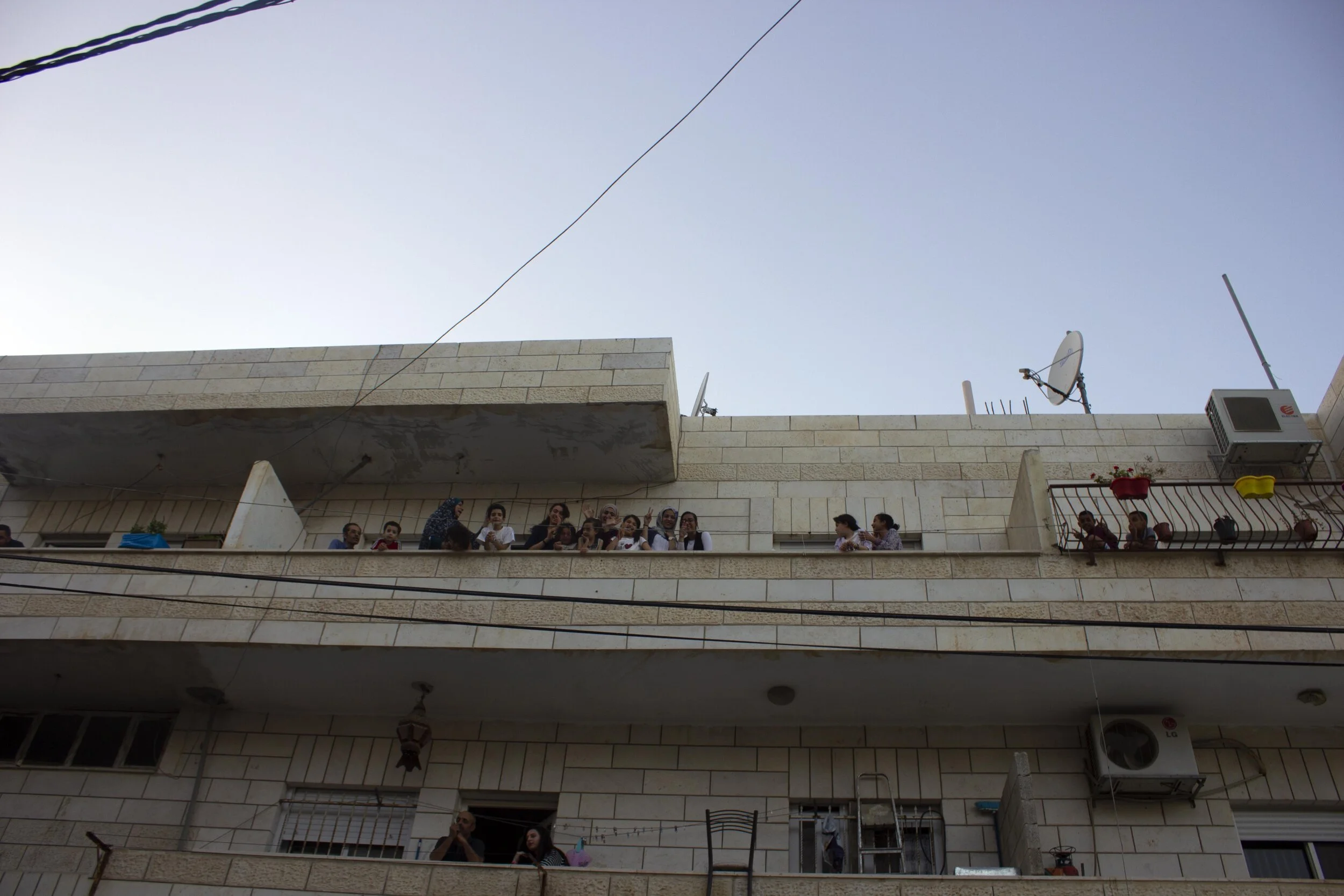 Children gather on a balcony to cheer at activists