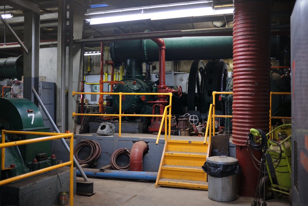  Moving between different rooms you can get a good sense for the way the building housing the compressors has slowly grown. Stairs like this transition between different rooms and air lines (red) pass through below the floor. This view looks from Com