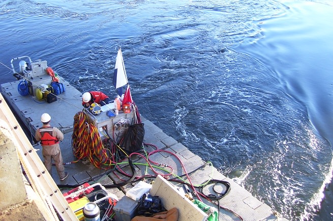 Dive supervisor discussing rigging operations with diver as ebb tide get moving