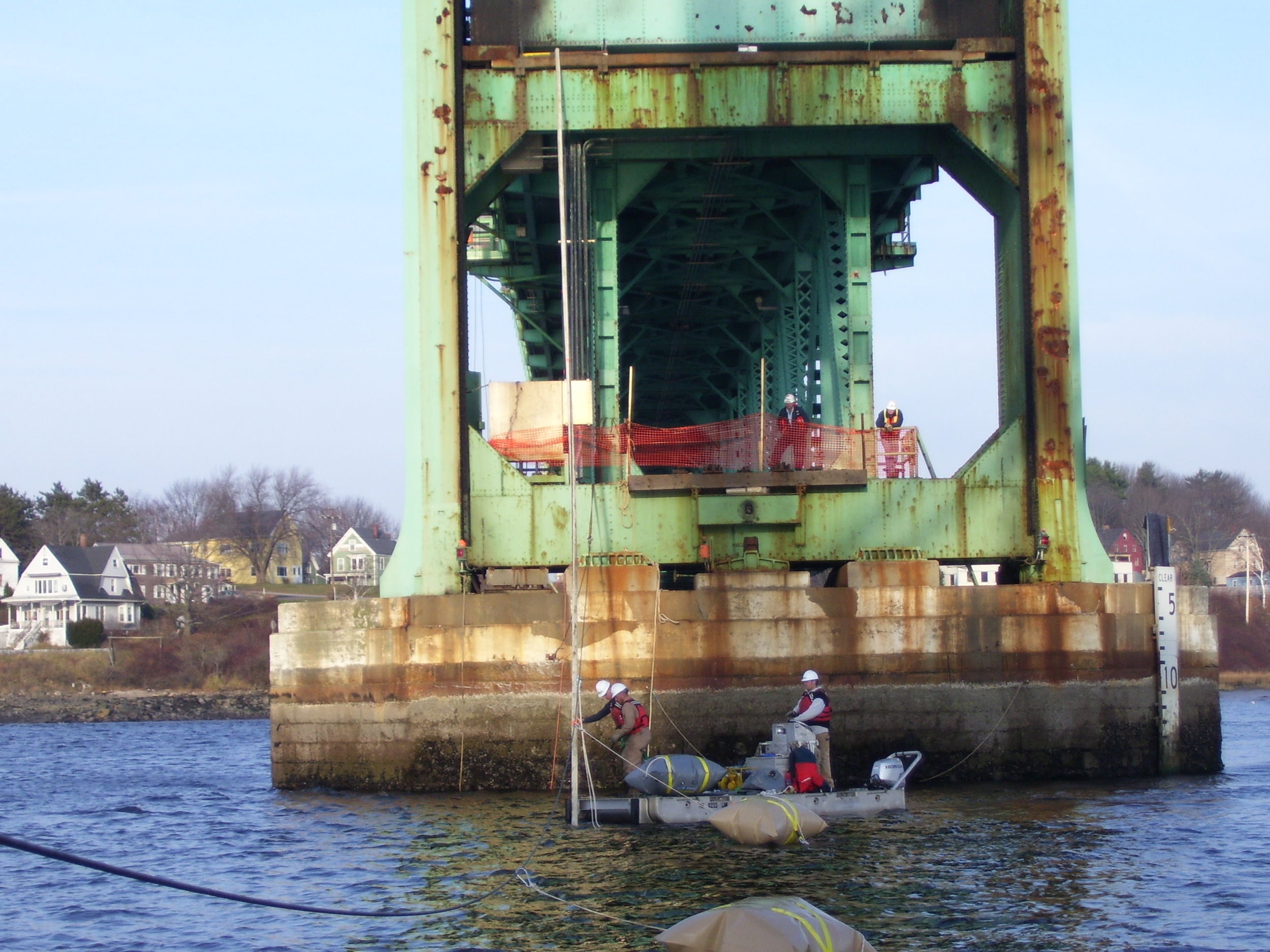 Bridge pier with new cable being deployed from bridge deck