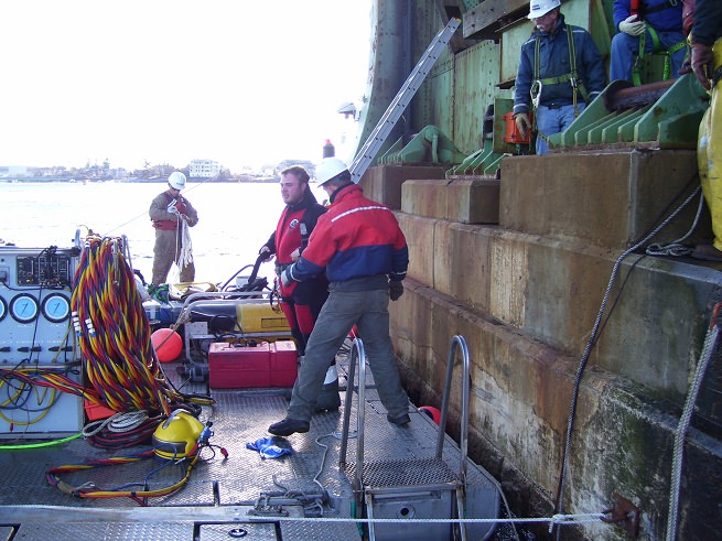 Diver dressing in while Cianbro's surface team readies for first cable pull